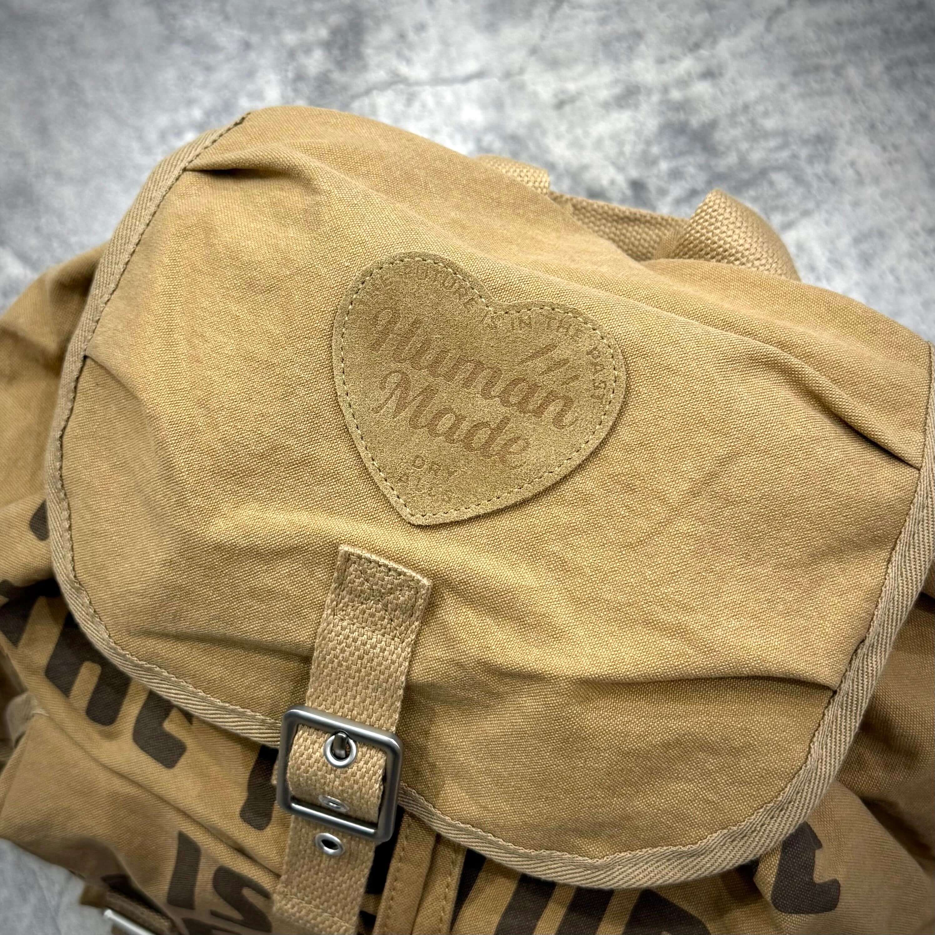 Human Made Hunting Backpack with heart-shaped logo detail on the flap, showcasing its unique design and quality.