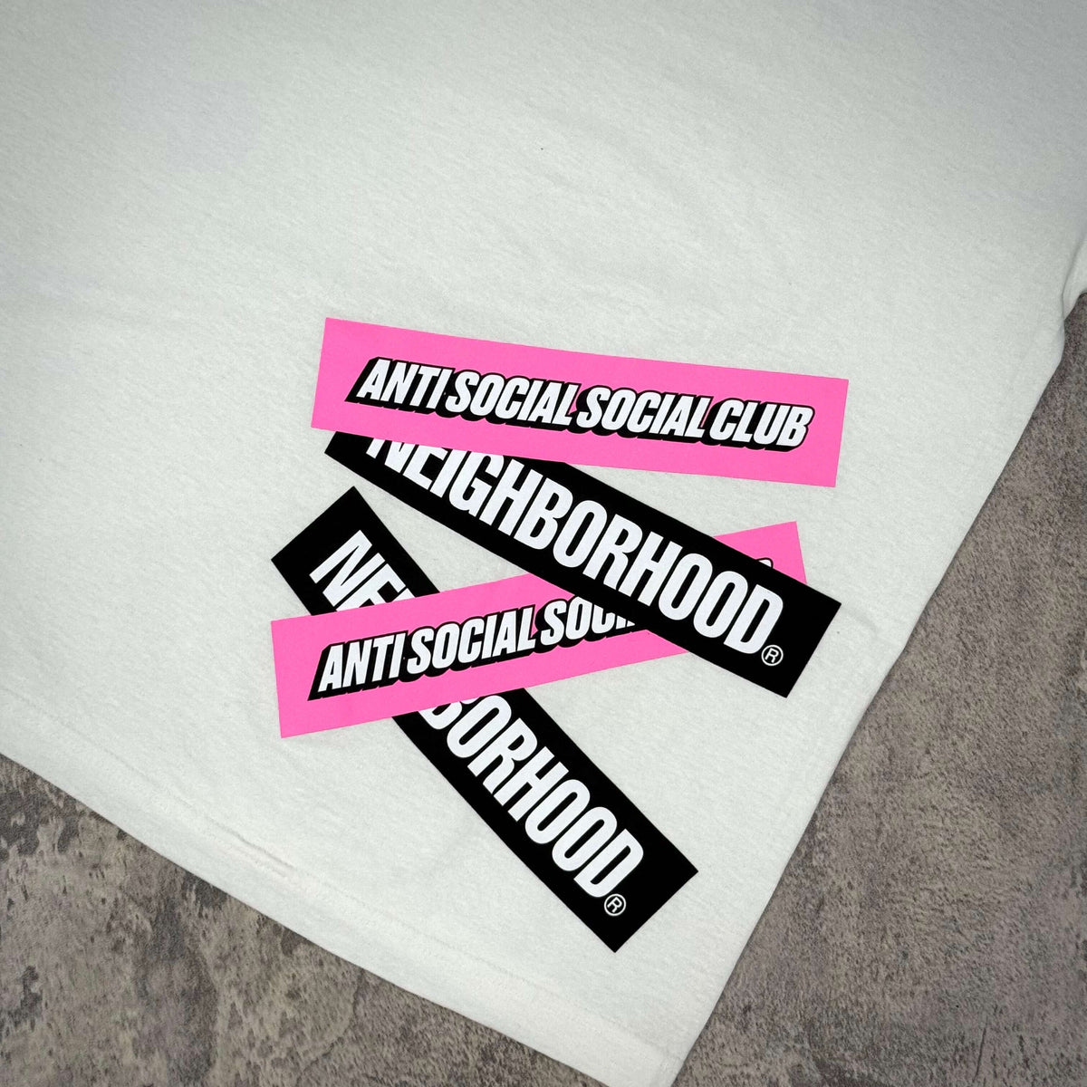 Anti Social Social Club x Neighborhood Stuck On You Tee with logo patches on a light background
