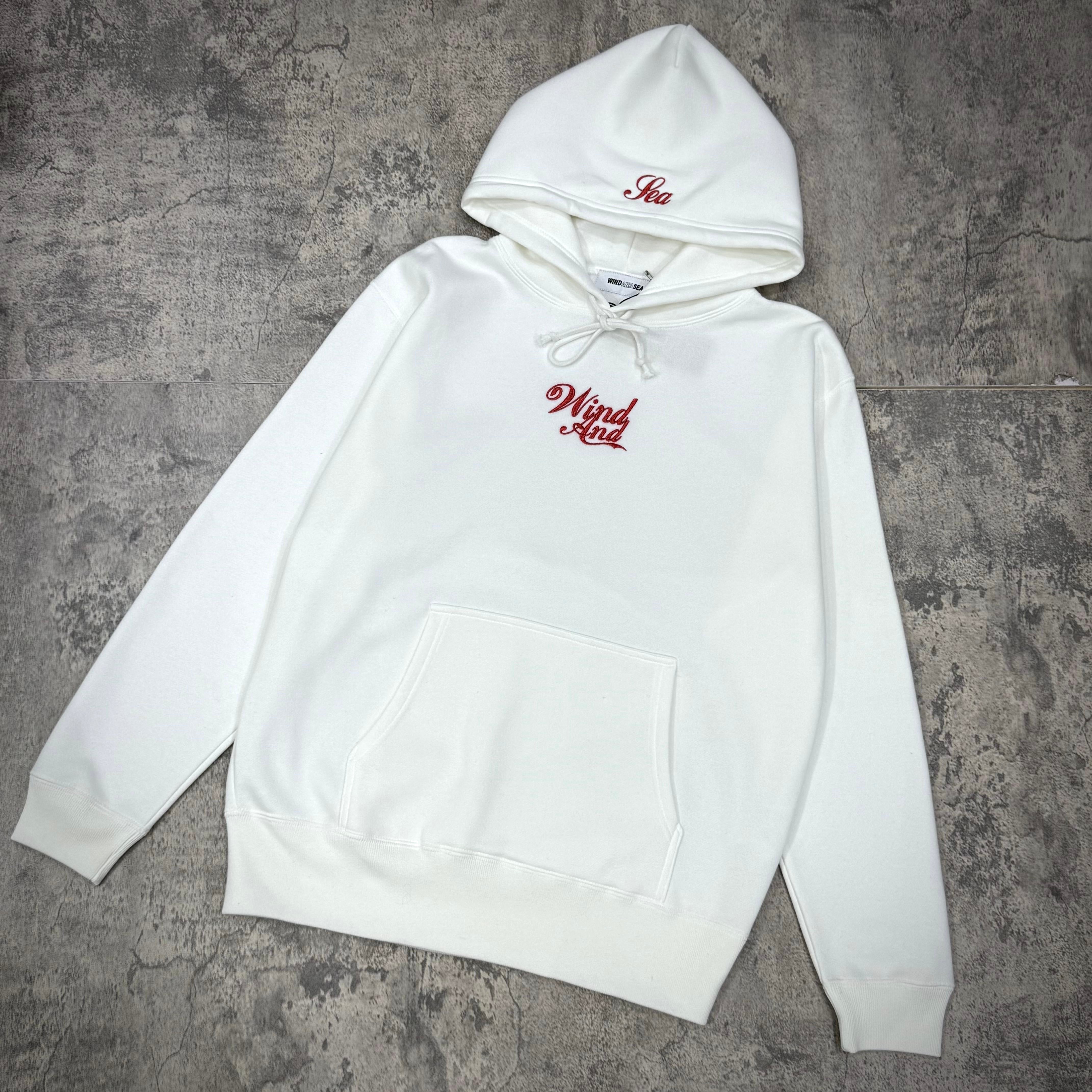 Wind And Sea Glitter Hoodie - Black / White displayed on a textured surface, showing its unique design and logo.