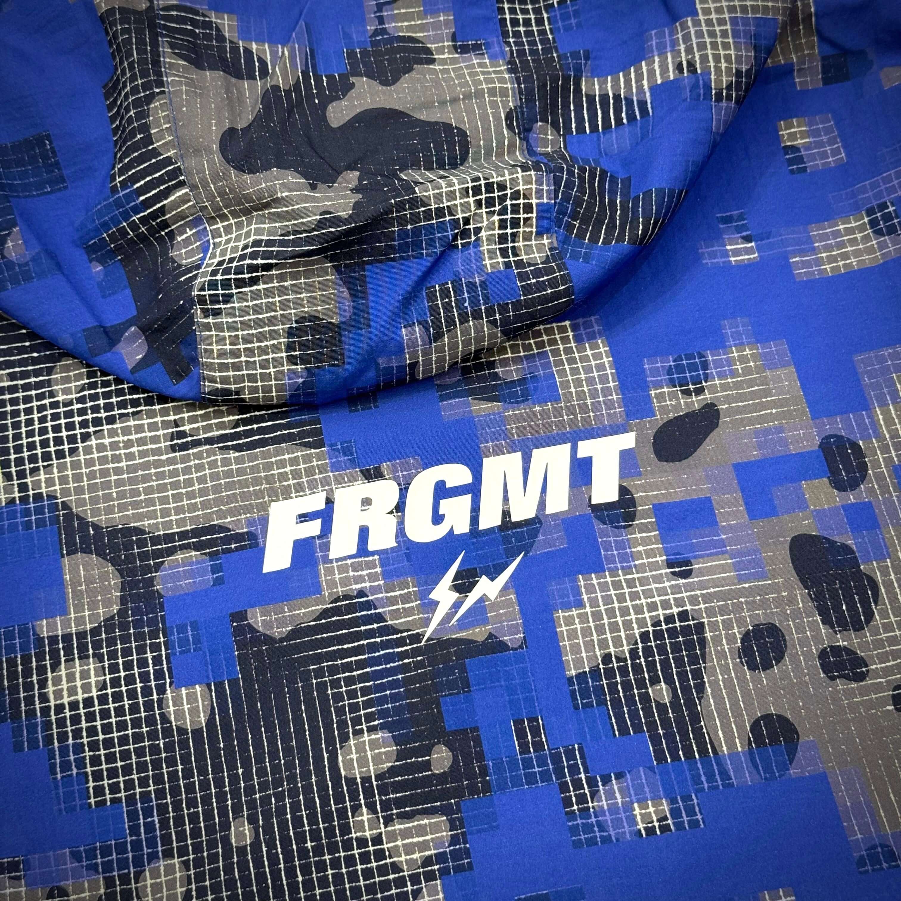 Fragment x FCRB Camouflage Nylon Blouson featuring a blue camouflage pattern with the FRGMT logo.