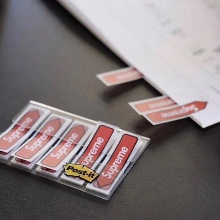 Supreme Post-it Flags - Red displayed with sheets of paper and labels, showcasing a stylish organization tool.