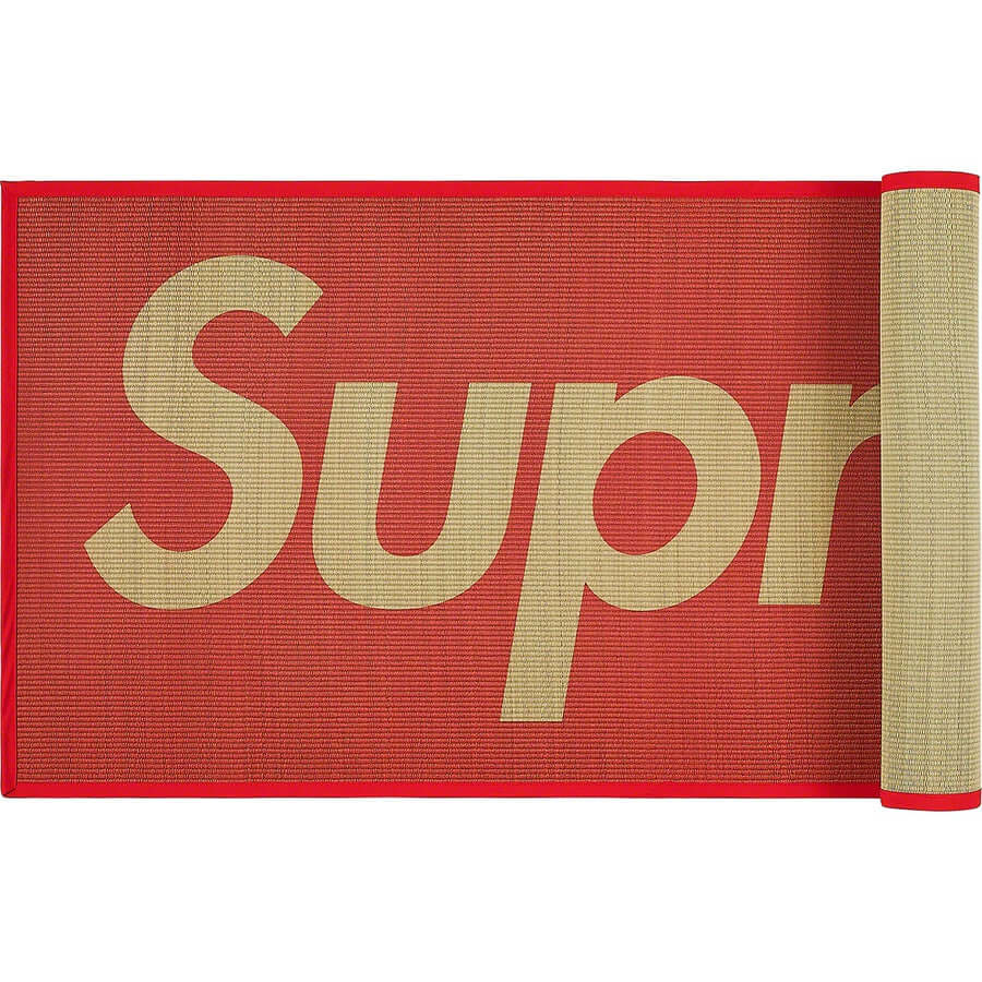 Supreme Woven Straw Mat in red with a woven design and large 'Supreme' lettering displayed prominently.