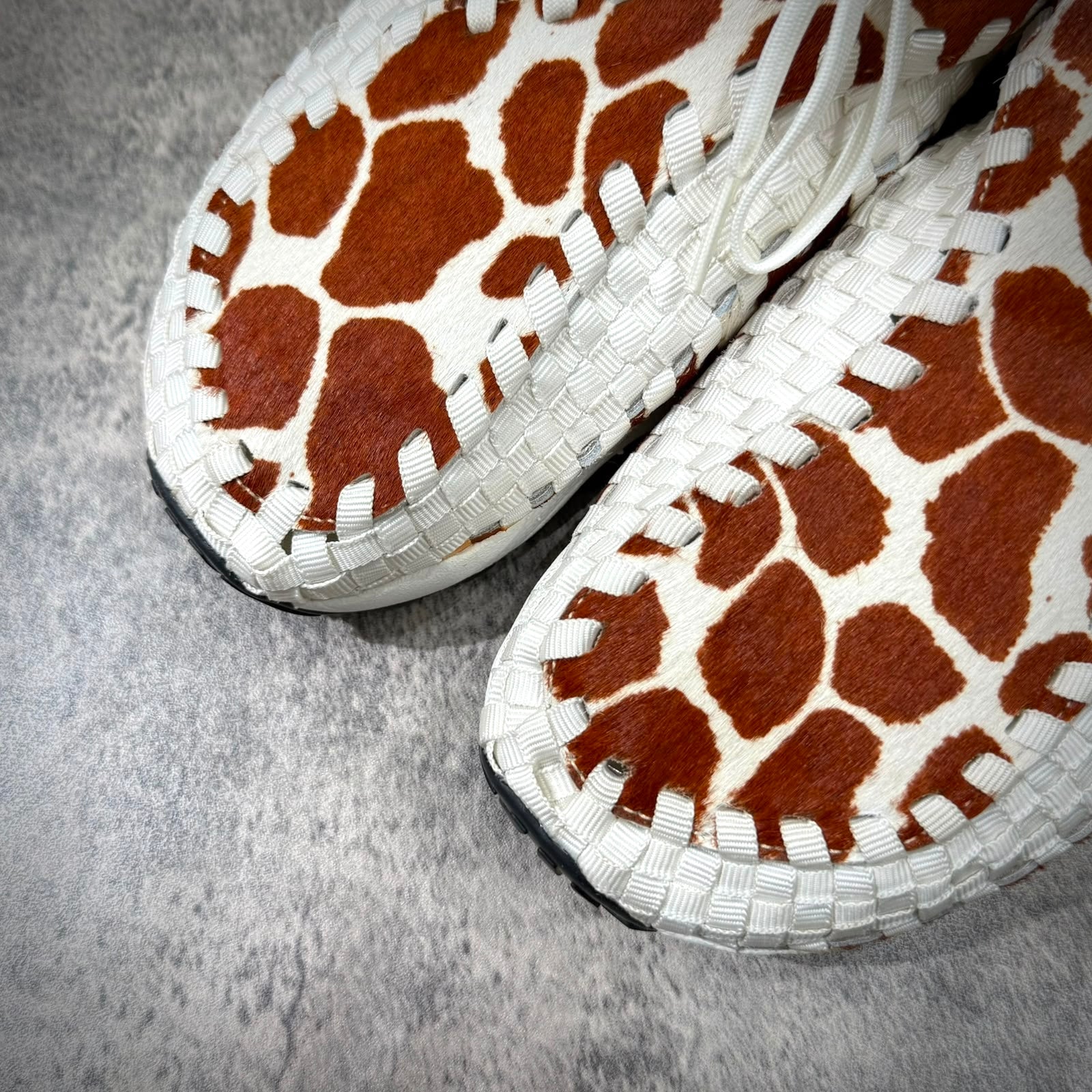 Close-up view of Nike Air Footscape Woven Cow Print sneakers featuring cowhide pattern and woven design.