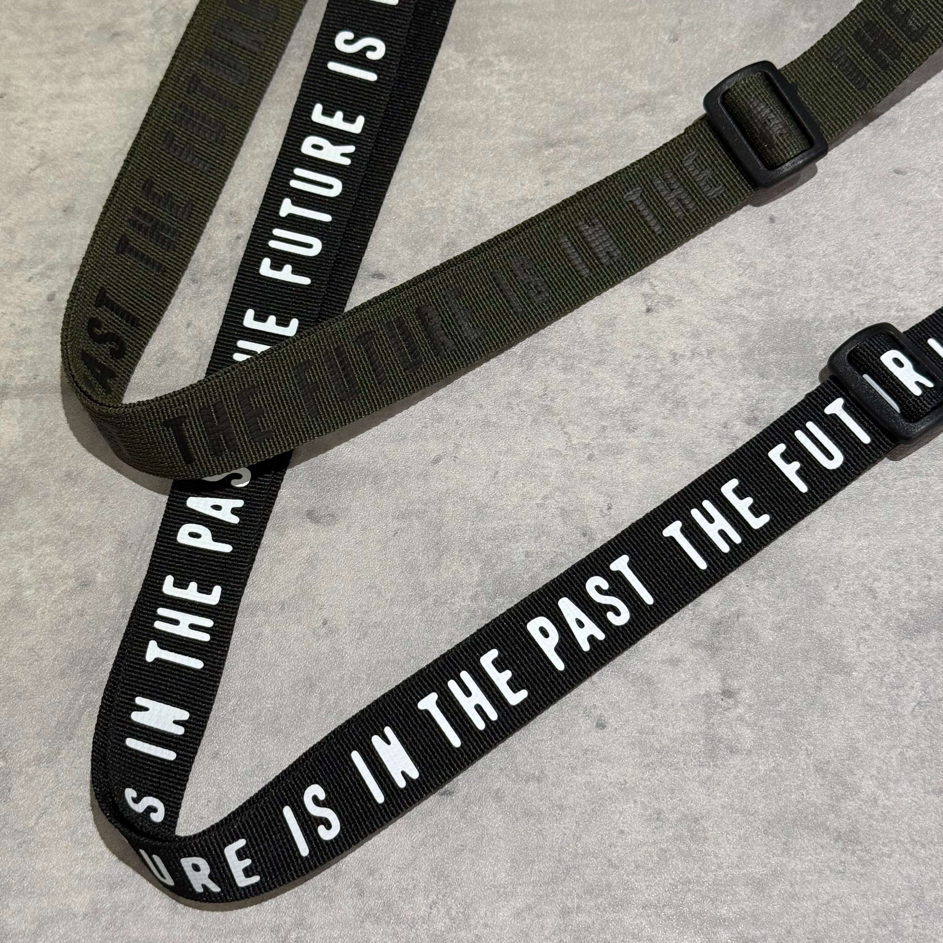 Human Made Military Pouch straps in black and olive green featuring a motivational quote on the textile.