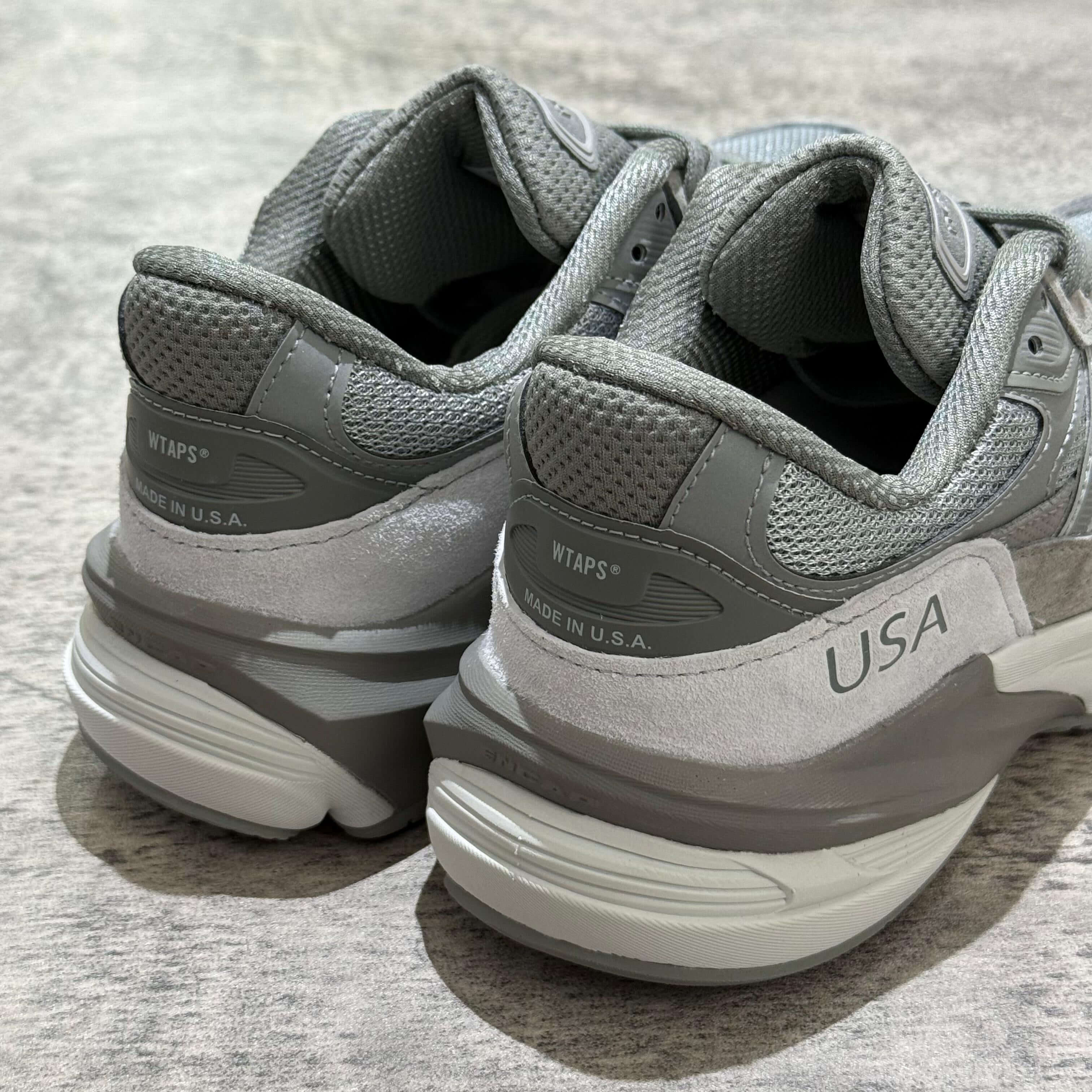 Close-up of the heel featuring the logo of New Balance x Wtaps 990v6 sneakers, showing the 'USA' tag.