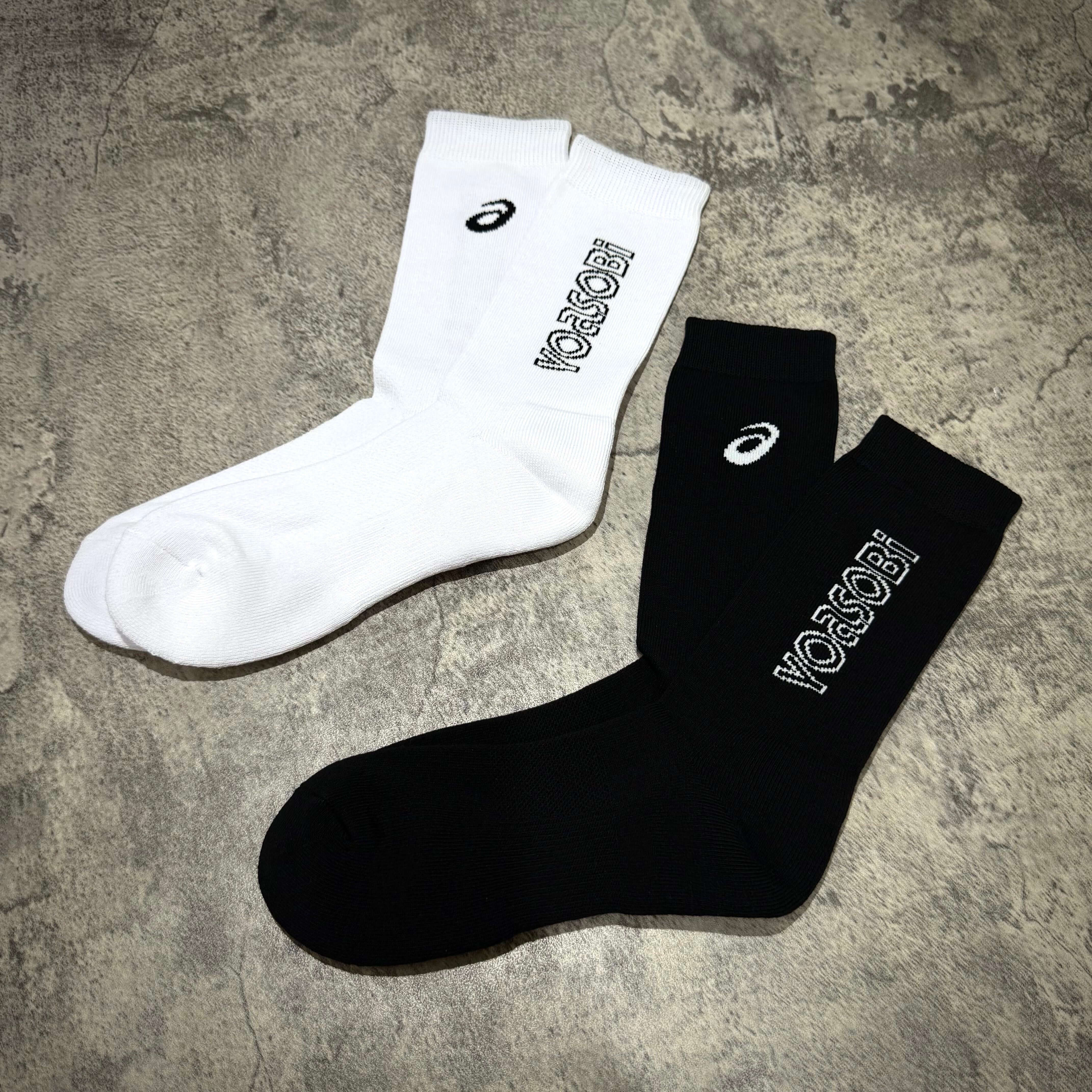 Yoasobi x Asics logo socks featuring white and black colors on a textured background.