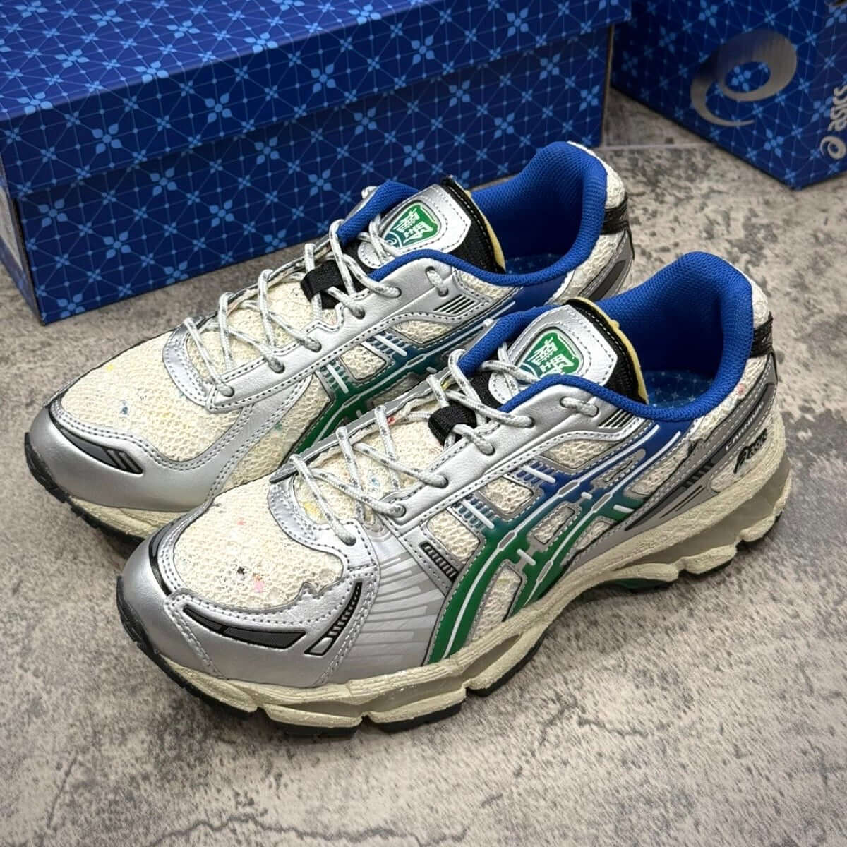 Carnival x Asics Gel Kayano 12.1 PHRA NAKHON sneakers with silver, blue, and green accents.