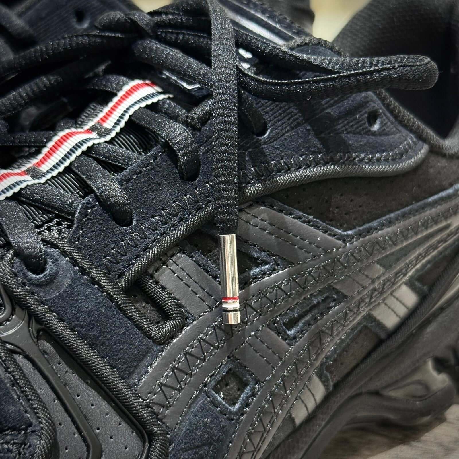Close-up of Thom Browne x Asics Gel-Kayano 14 - Black sneakers showcasing intricate details and unique lacing.