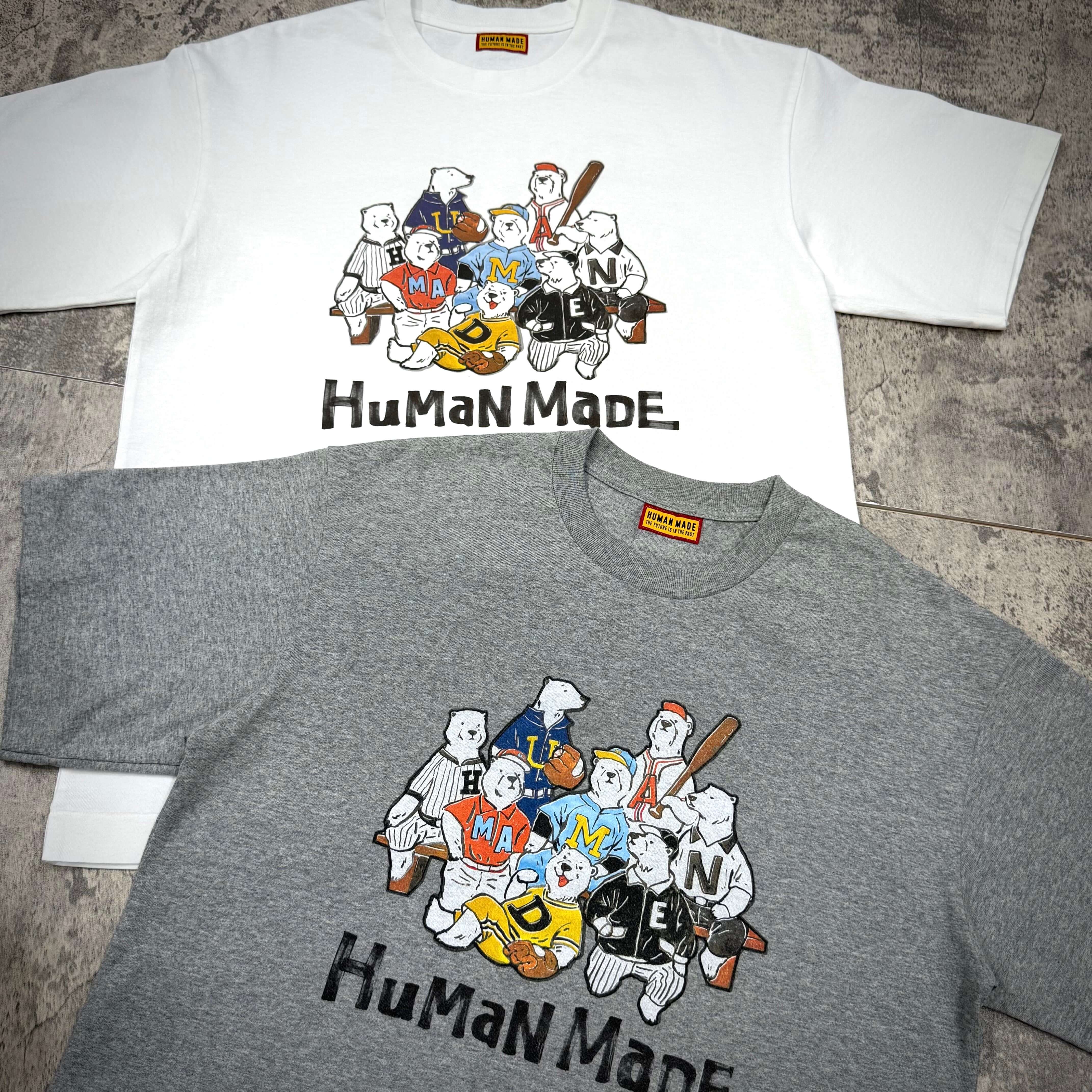 Two Human Made Graphic Tees HM31CS009 in white and grey featuring playful cartoon graphics and text.