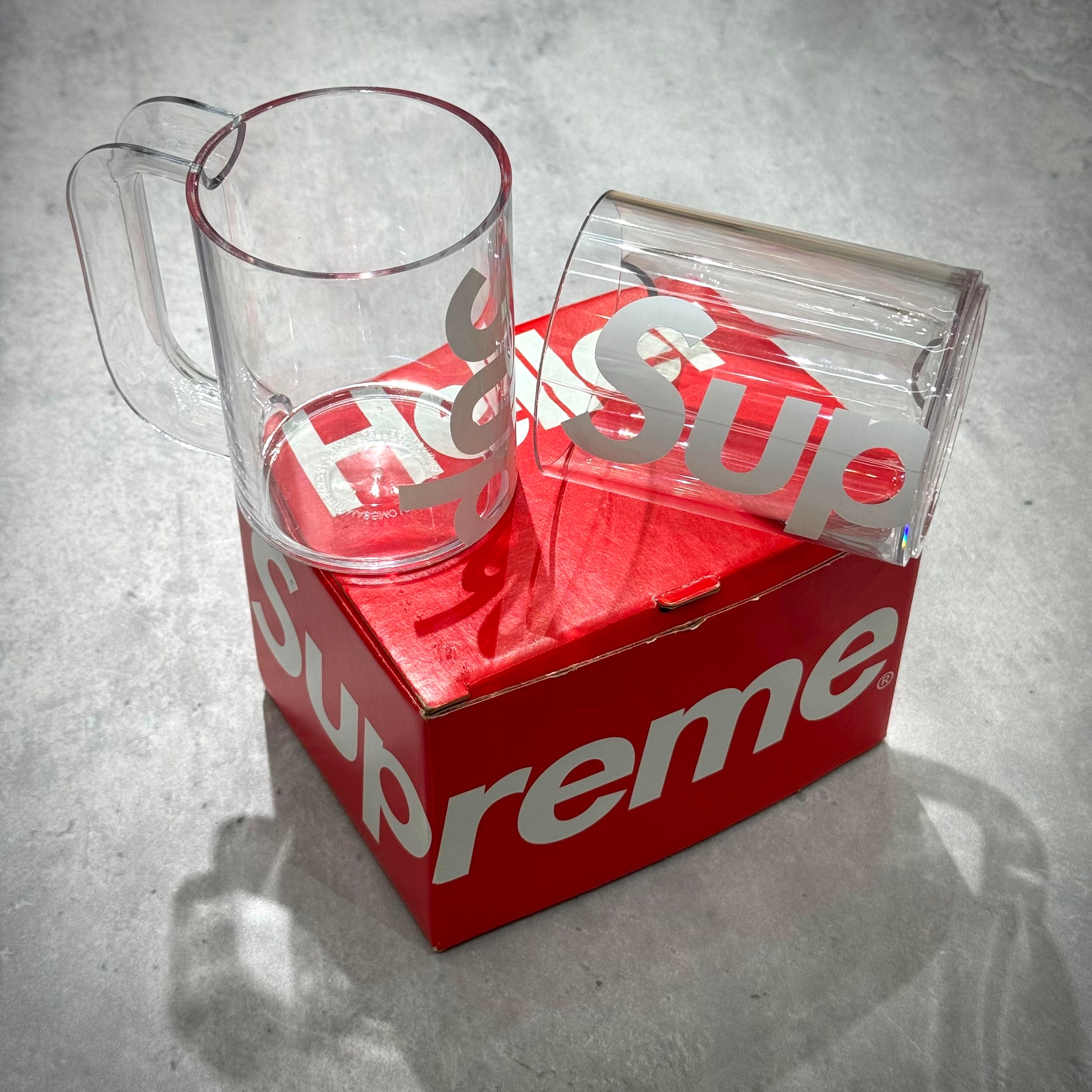 Supreme Heller Mugs (Set of 2) - Clear displayed on a red box with Supreme logo.