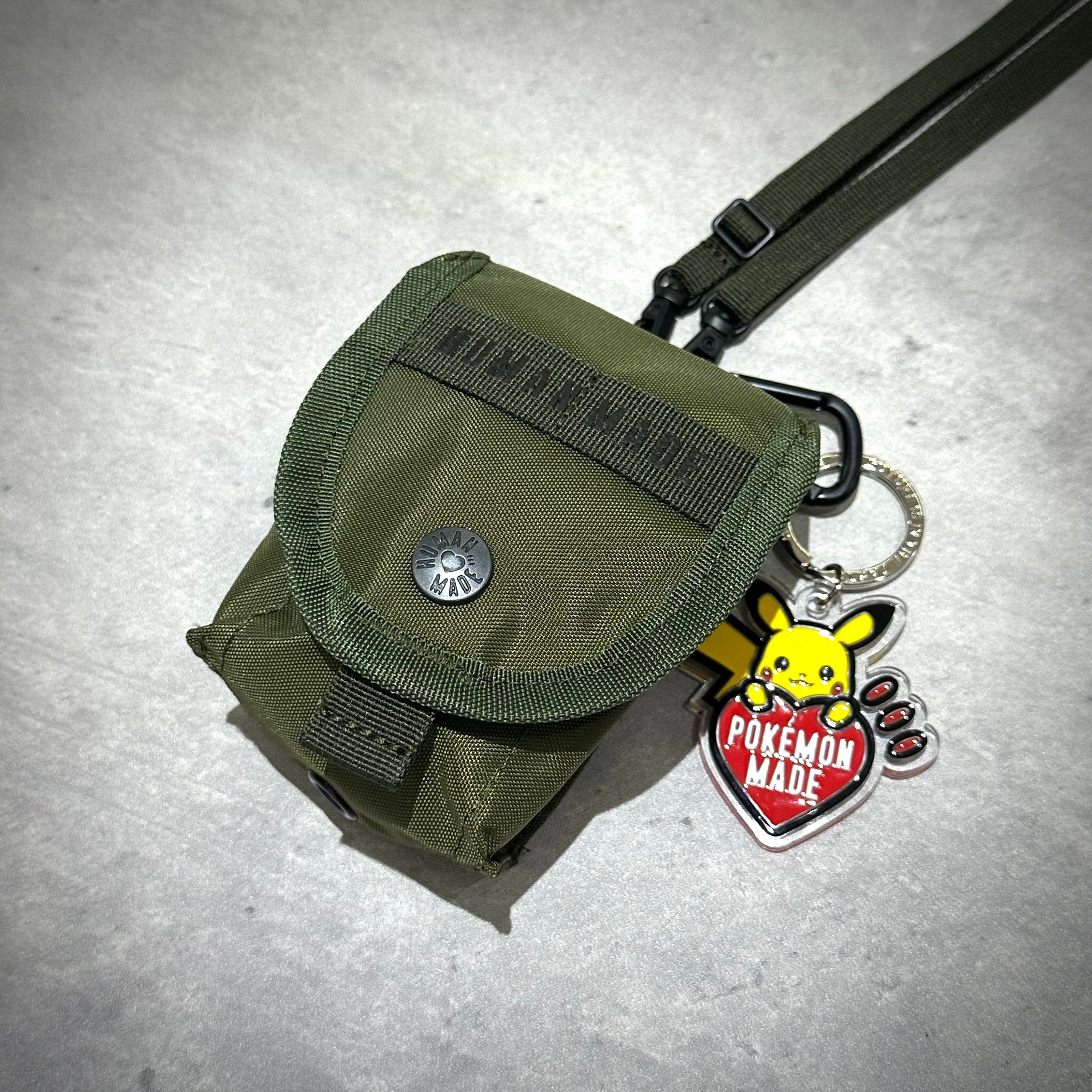 Human Made Military Multi Pouch Mini with Pikachu keychain, olive green design, ideal for casual use.