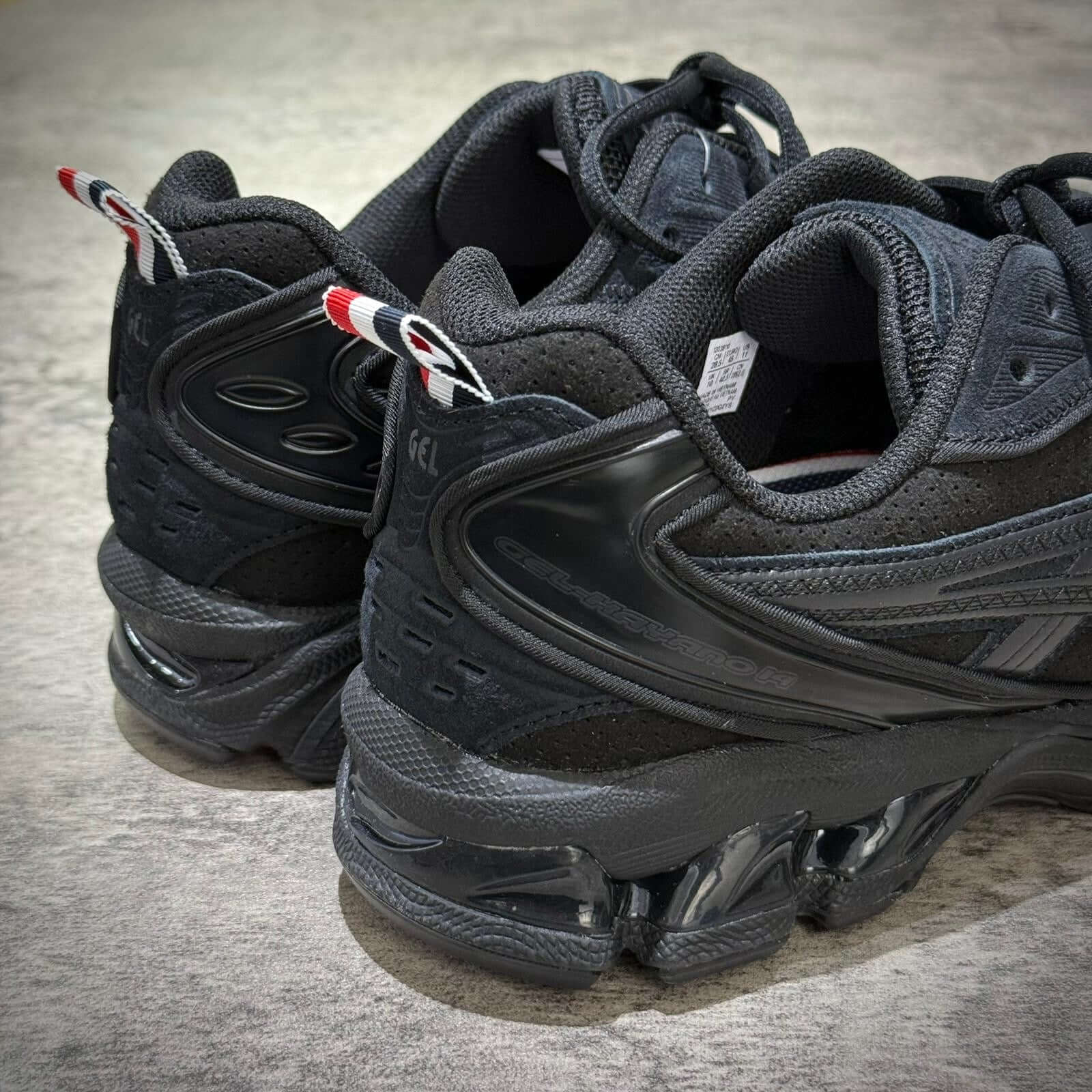 Thom Browne x Asics Gel-Kayano 14 in black, showcasing the heel and side design with a sporty aesthetic.