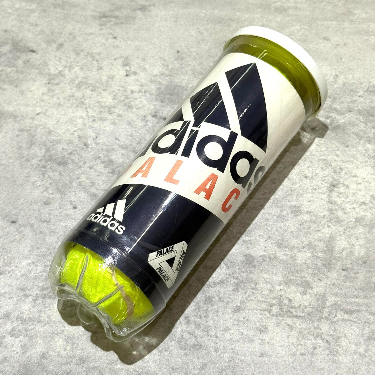 Palace x adidas Tennis Balls in a clear canister with bold logo design.