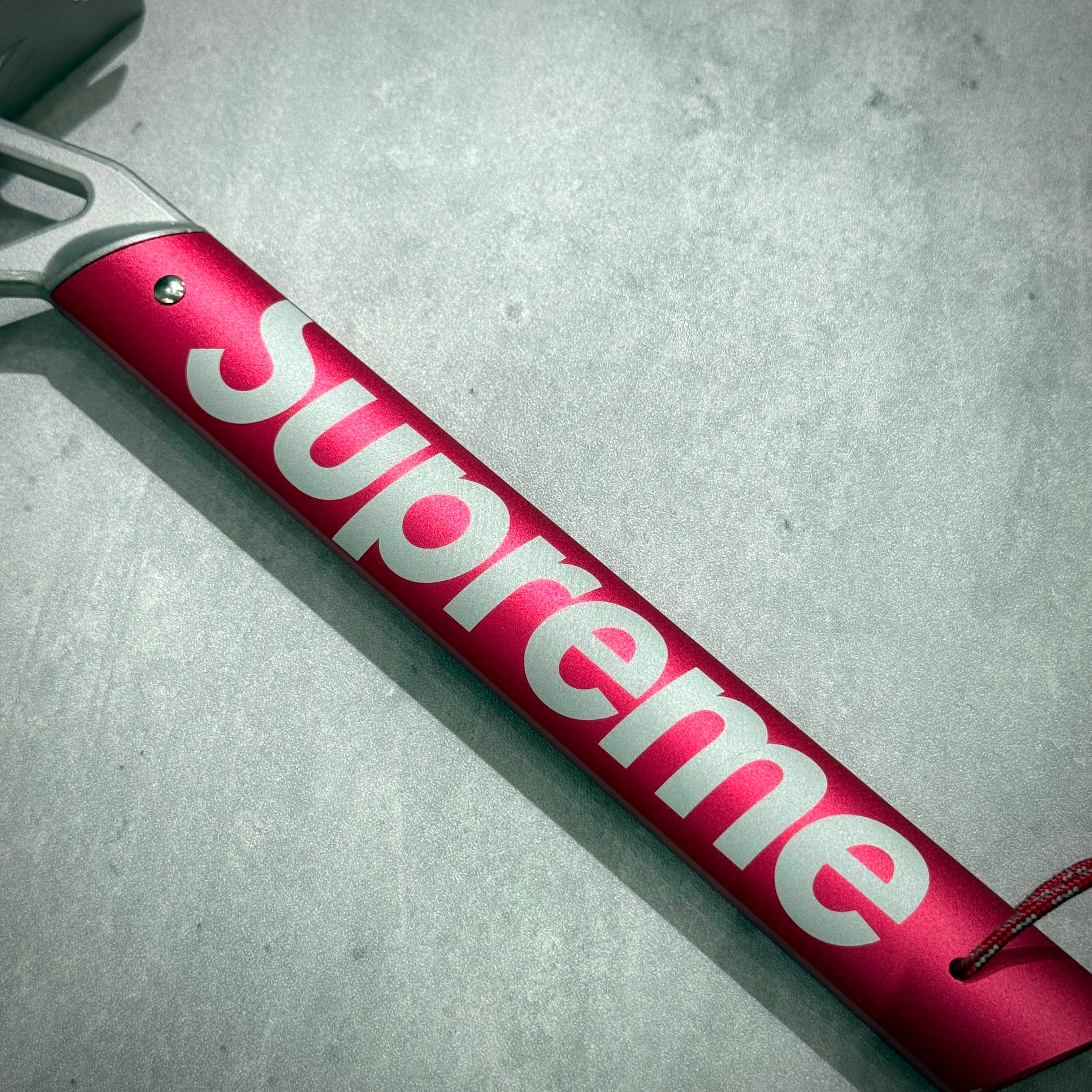 Supreme x MSR Camp Hammer - Red close-up showing engraved logo and handle design.