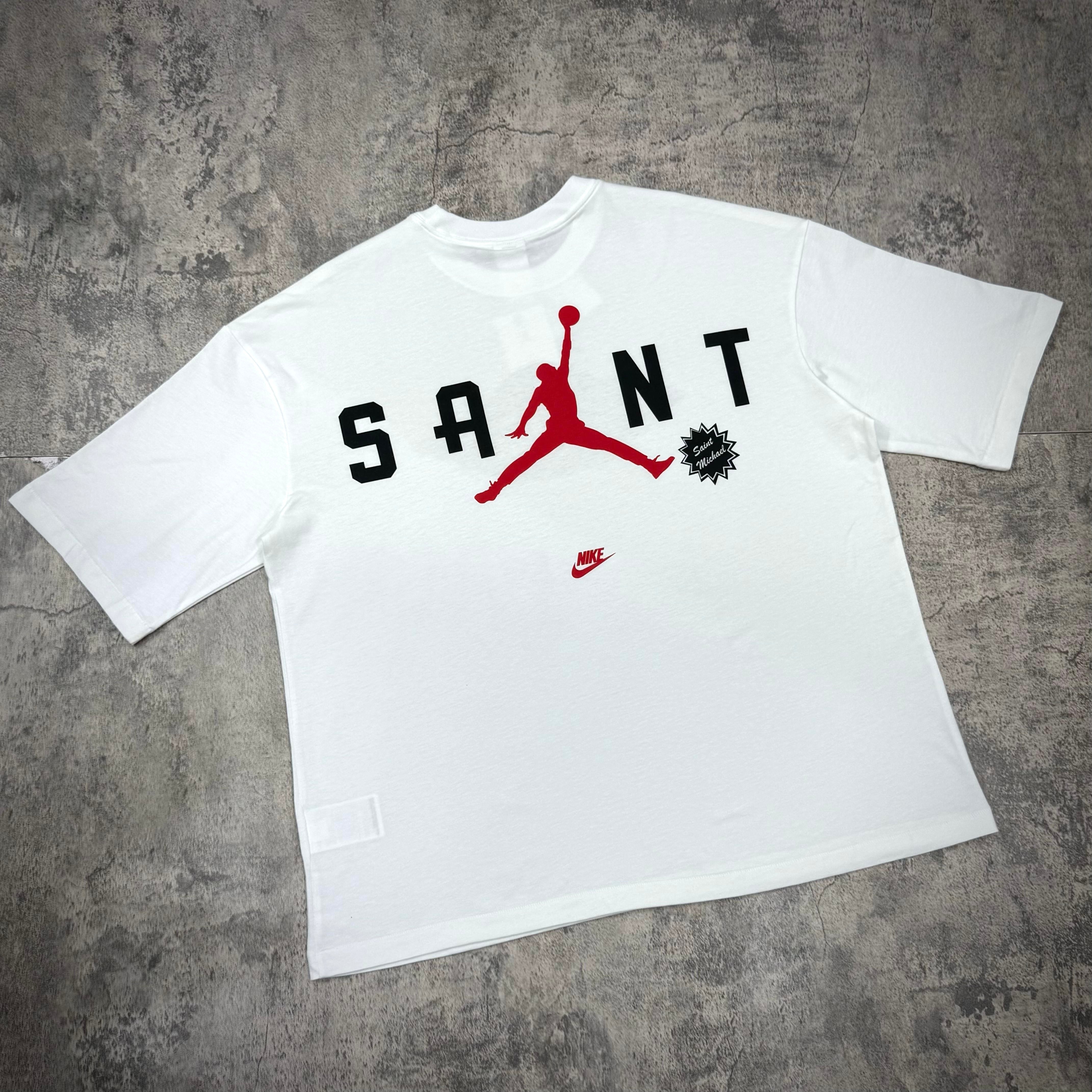 Saint Mxxxxxx Michael Jordan TIME CAPSULE Tee featuring iconic Jordan logo and bold lettering in red and black on a white background.