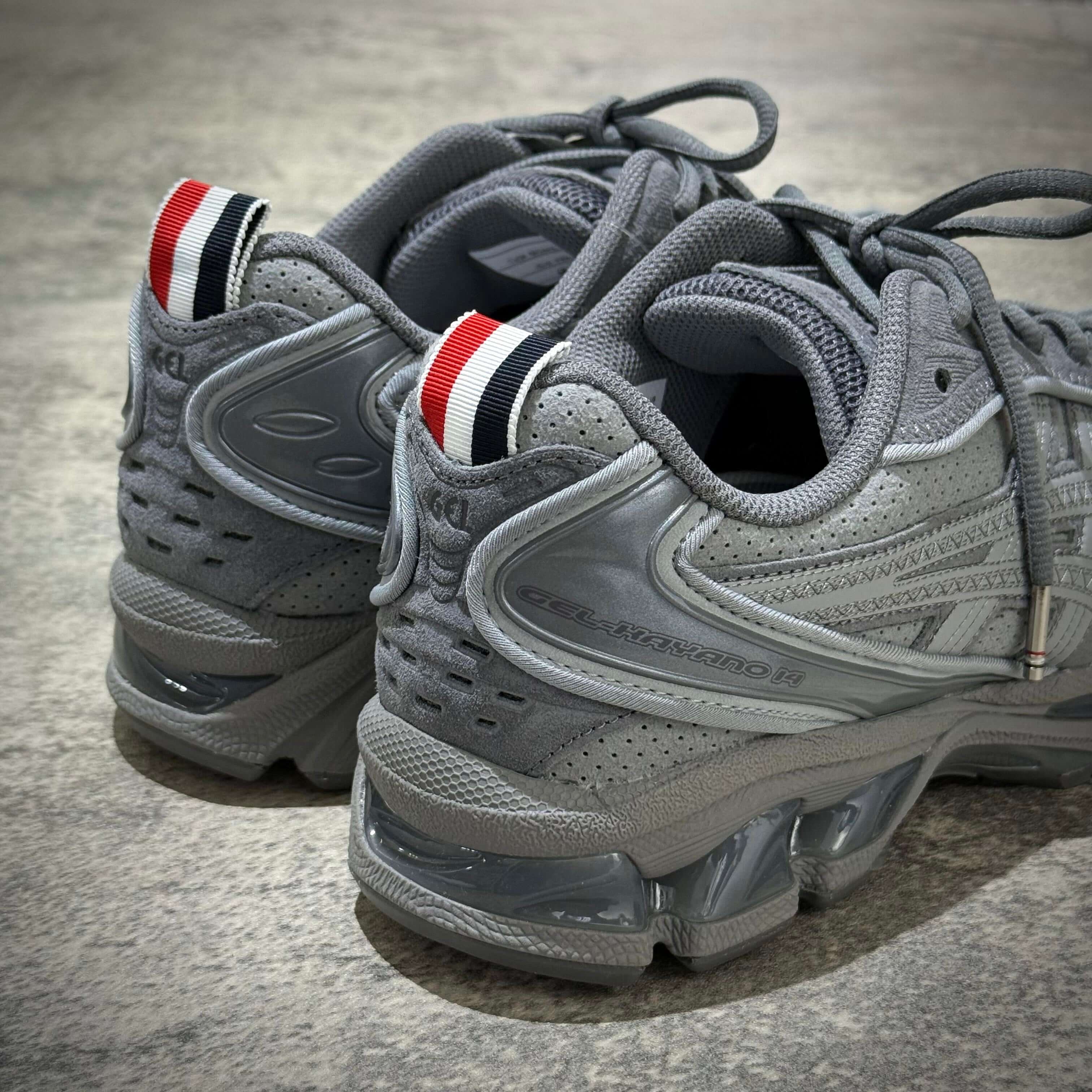 Thom Browne x Asics Gel-Kayano 14 in grey featuring iconic detailing and modern design.