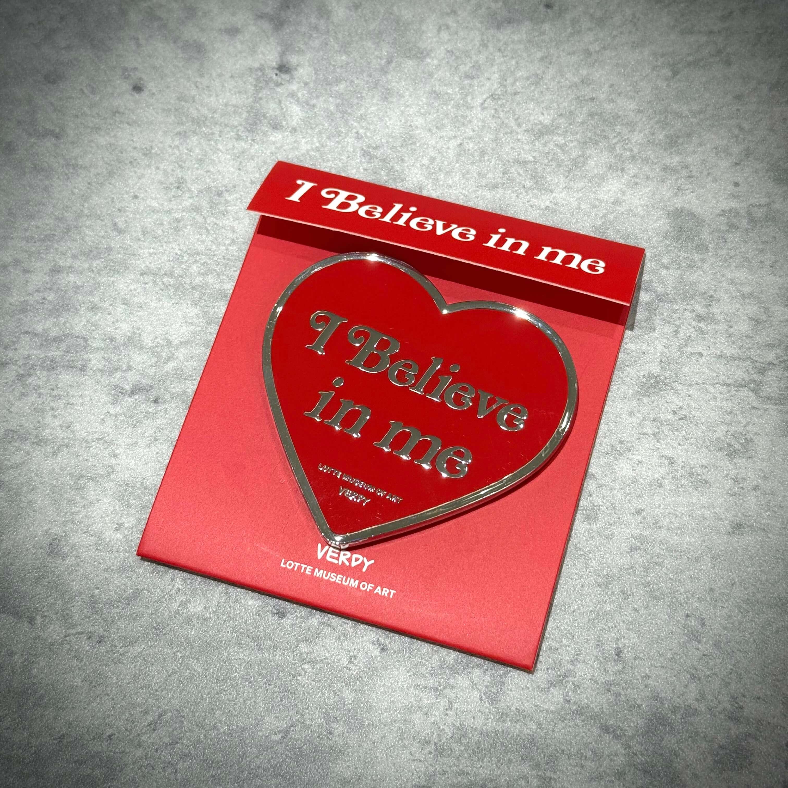 Verdy x Lottemuseum heart-shaped accessory with the text 'I Believe in me' on a red background