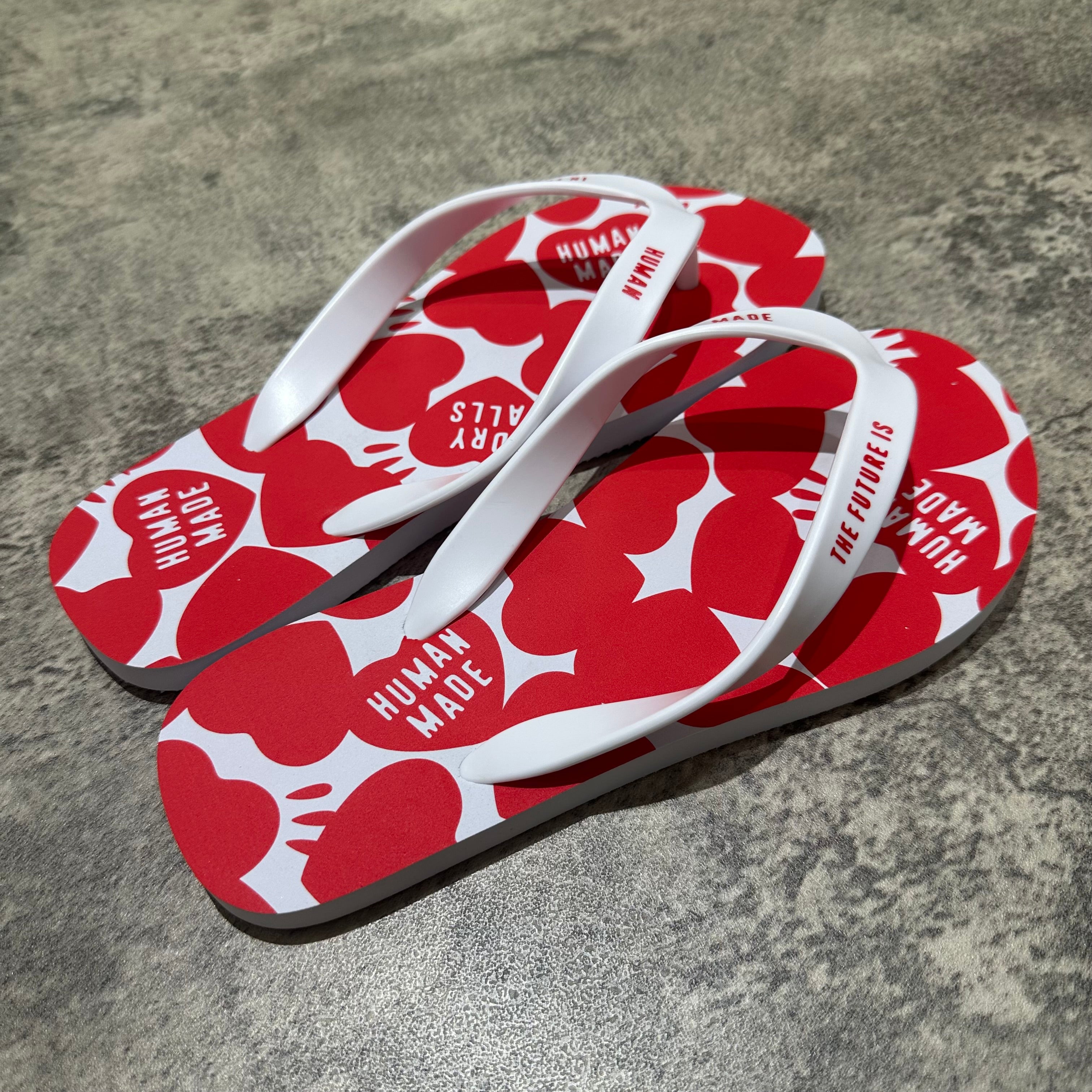 Human Made Sandal with a vibrant red pattern featuring hearts, displayed on a textured surface.