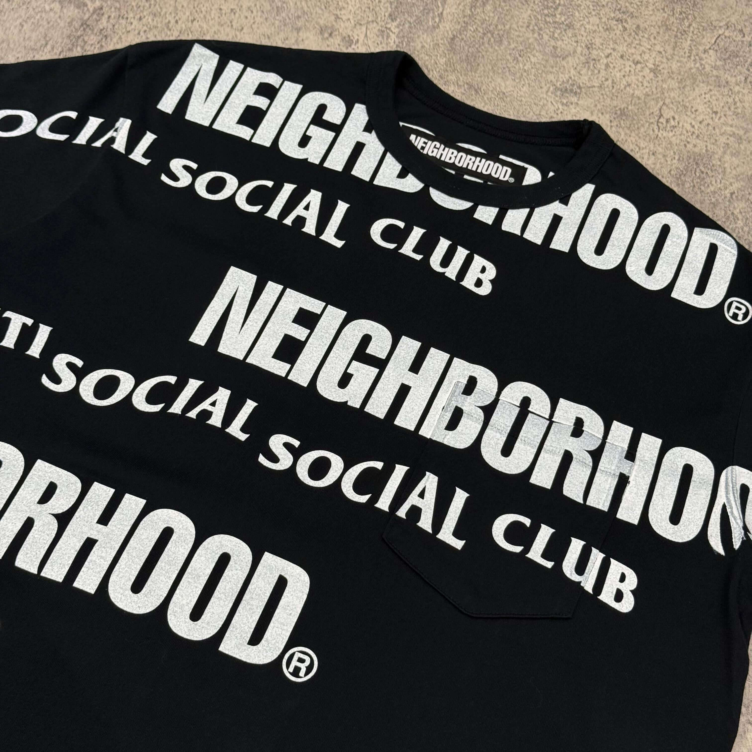 ASSC x Neighborhood tee featuring bold Neighborhood Social Club prints in white on a black background.
