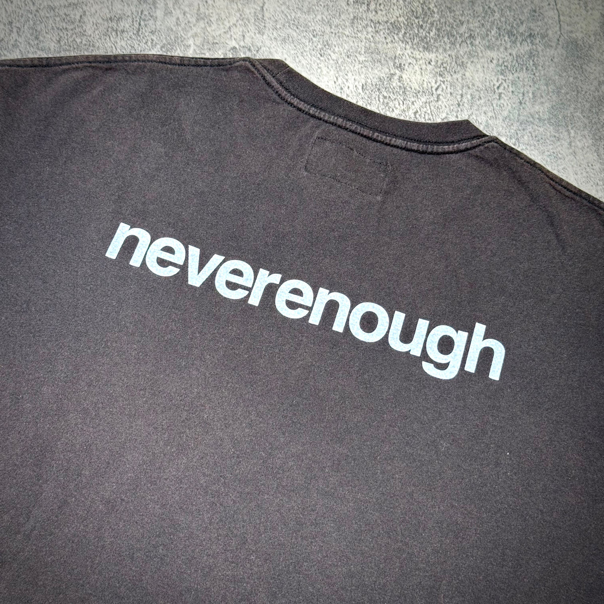 thisisneverthat x Fragment Design Tee - Off Black, featuring the word 'neverenough' on the back.