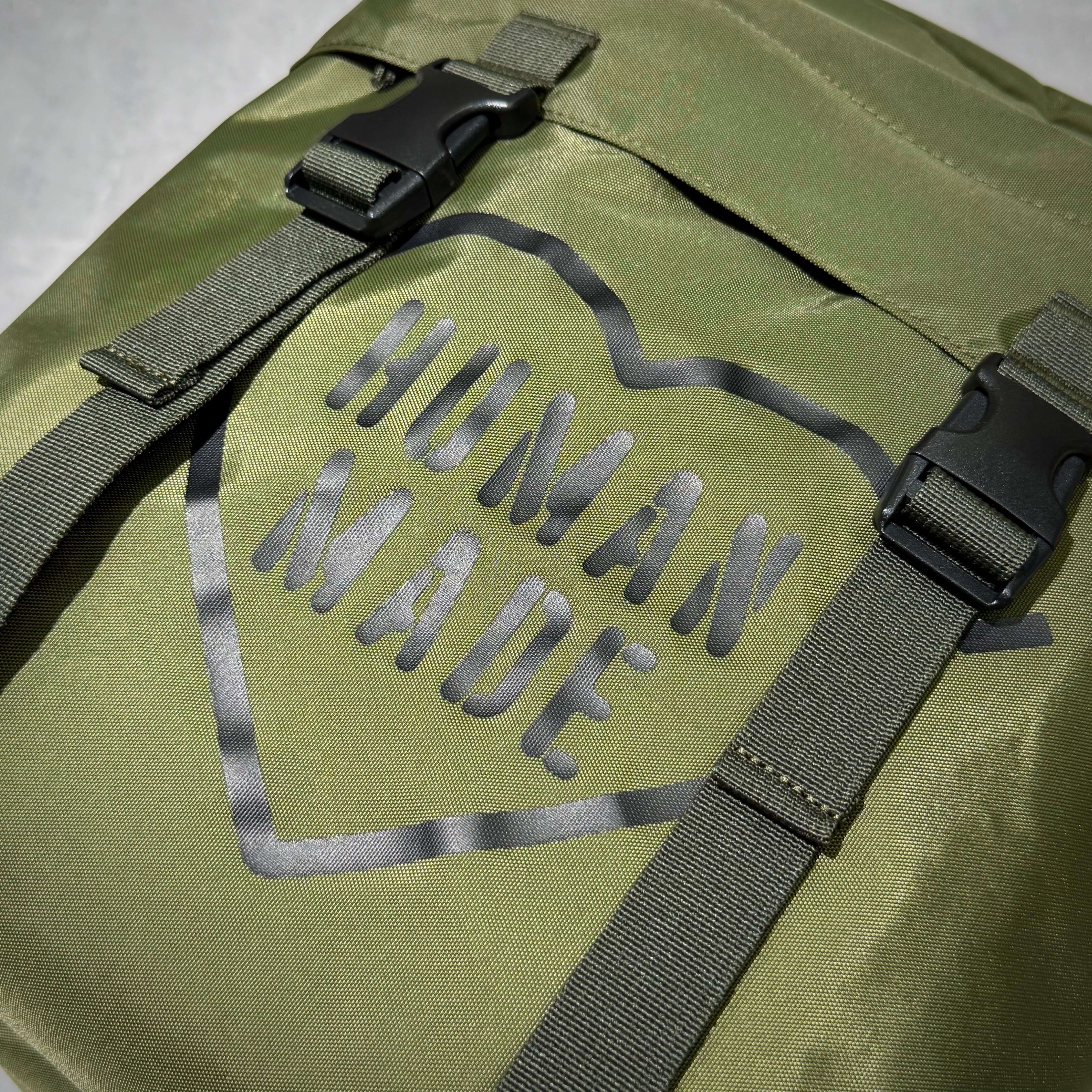 Human Made Military Backpack featuring olive green fabric and bold logo design.