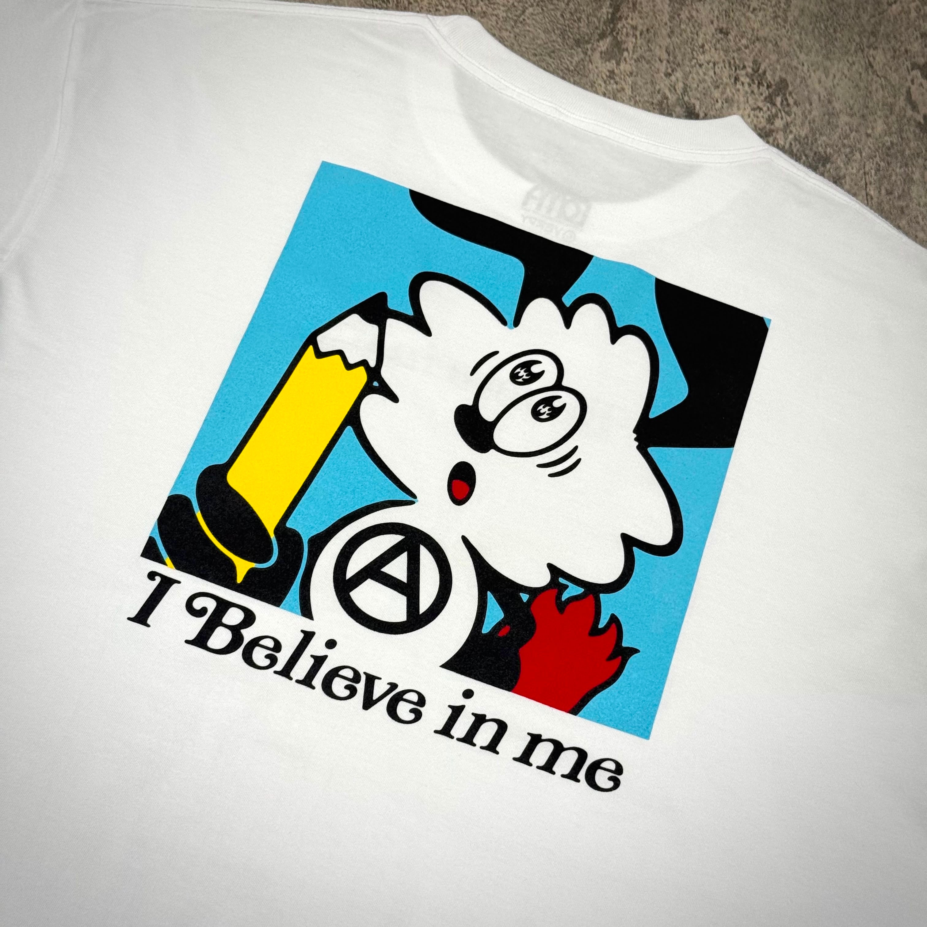 I Believe in me graphic print on white T-shirt featuring cartoon character and pencil design.