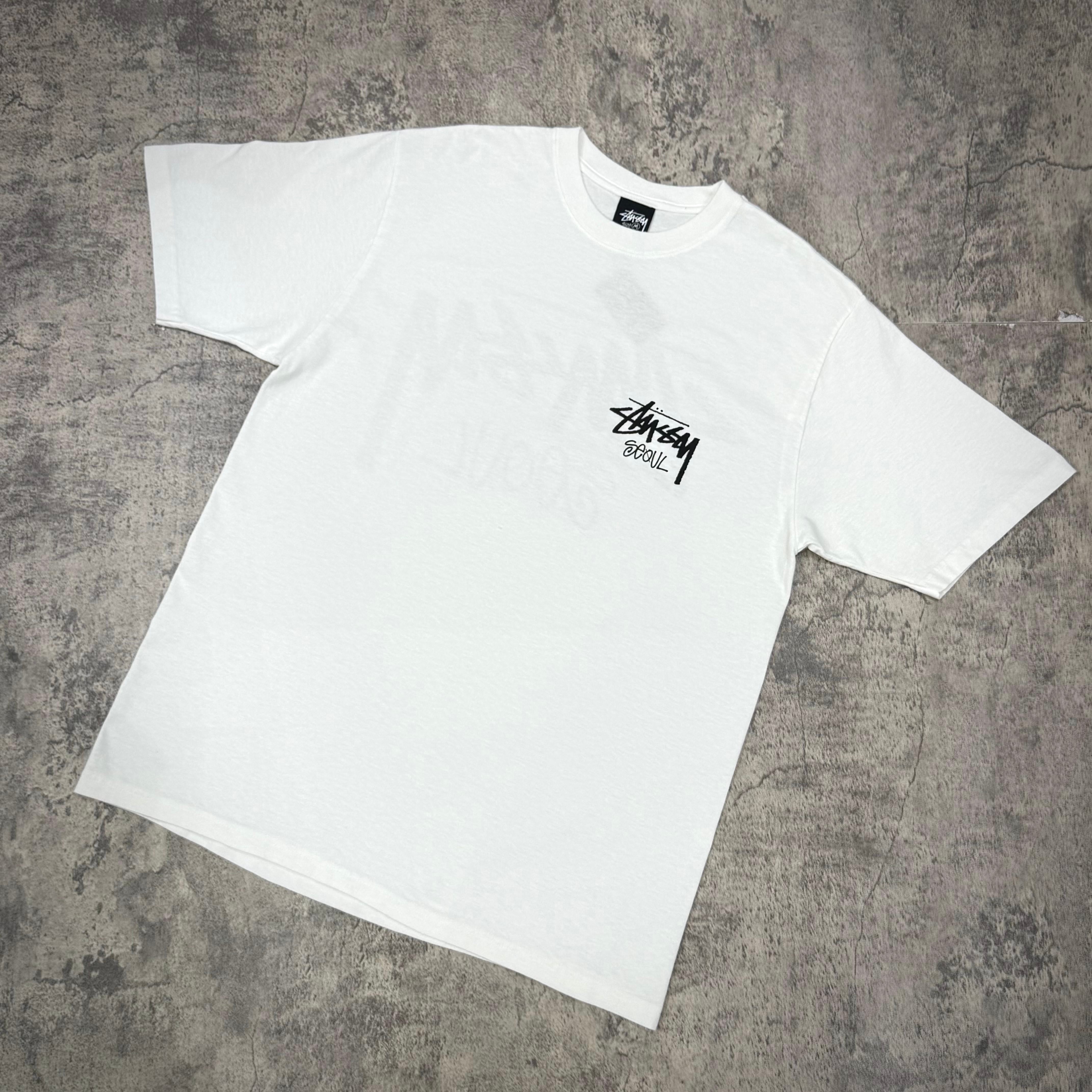 Stussy Seoul Exclusive Logo Tee - Black / White displayed on a gray background