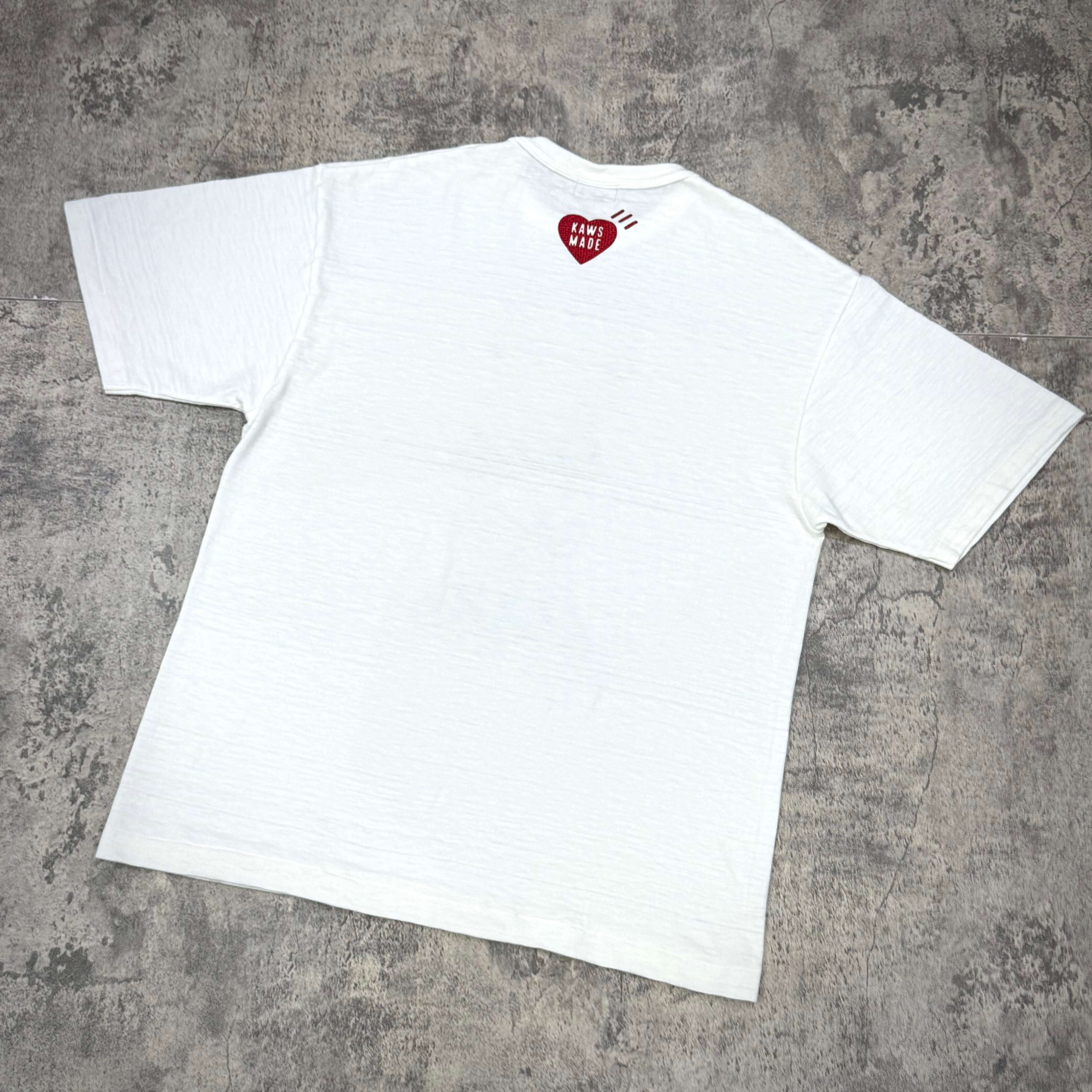 Back view of the Human Made Bangkok Exclusive Thailand Kaws Holiday Logo Tee, featuring a heart graphic.