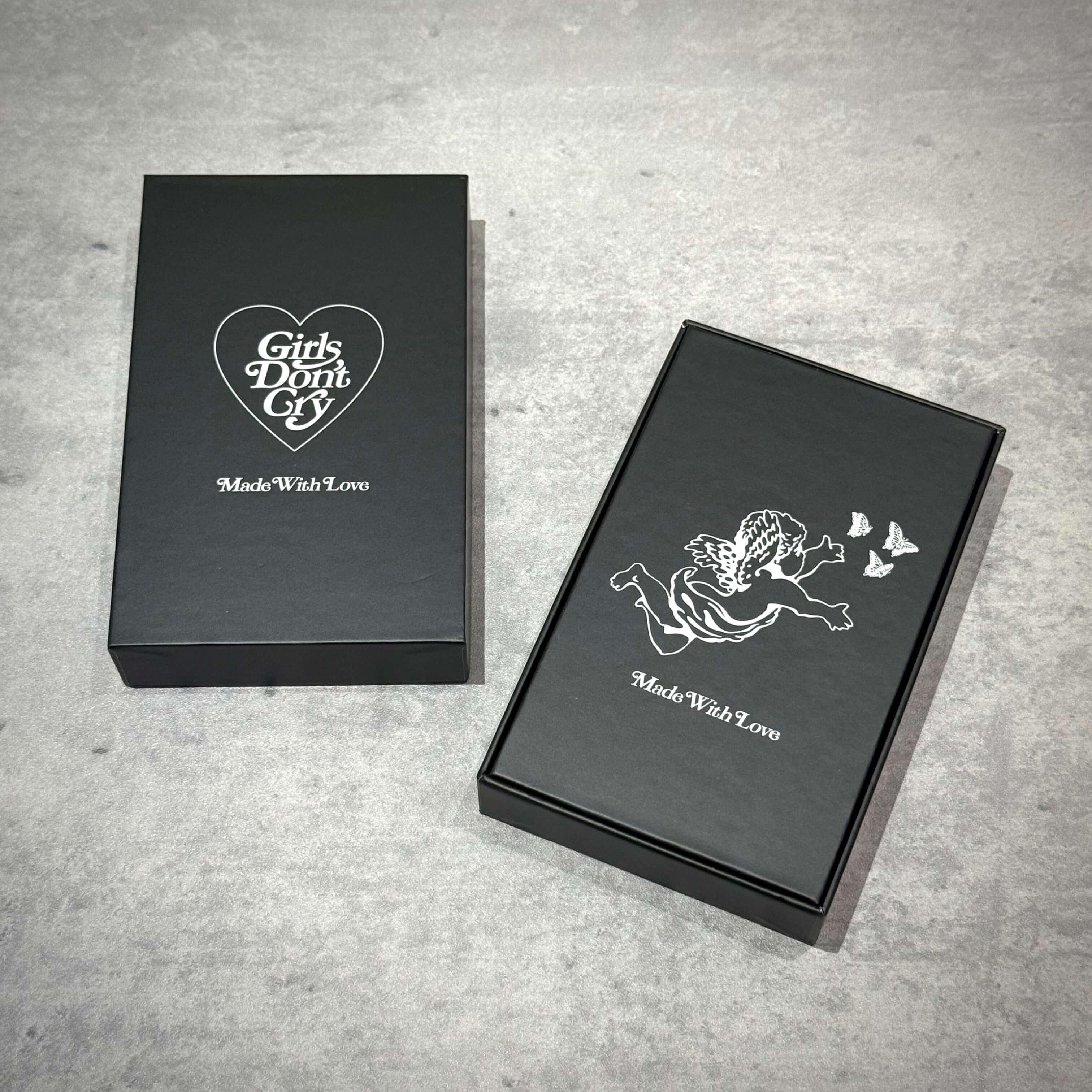 Girls Don't Cry Tortoise Shell Keyring packaging box design with heart and angel graphics.