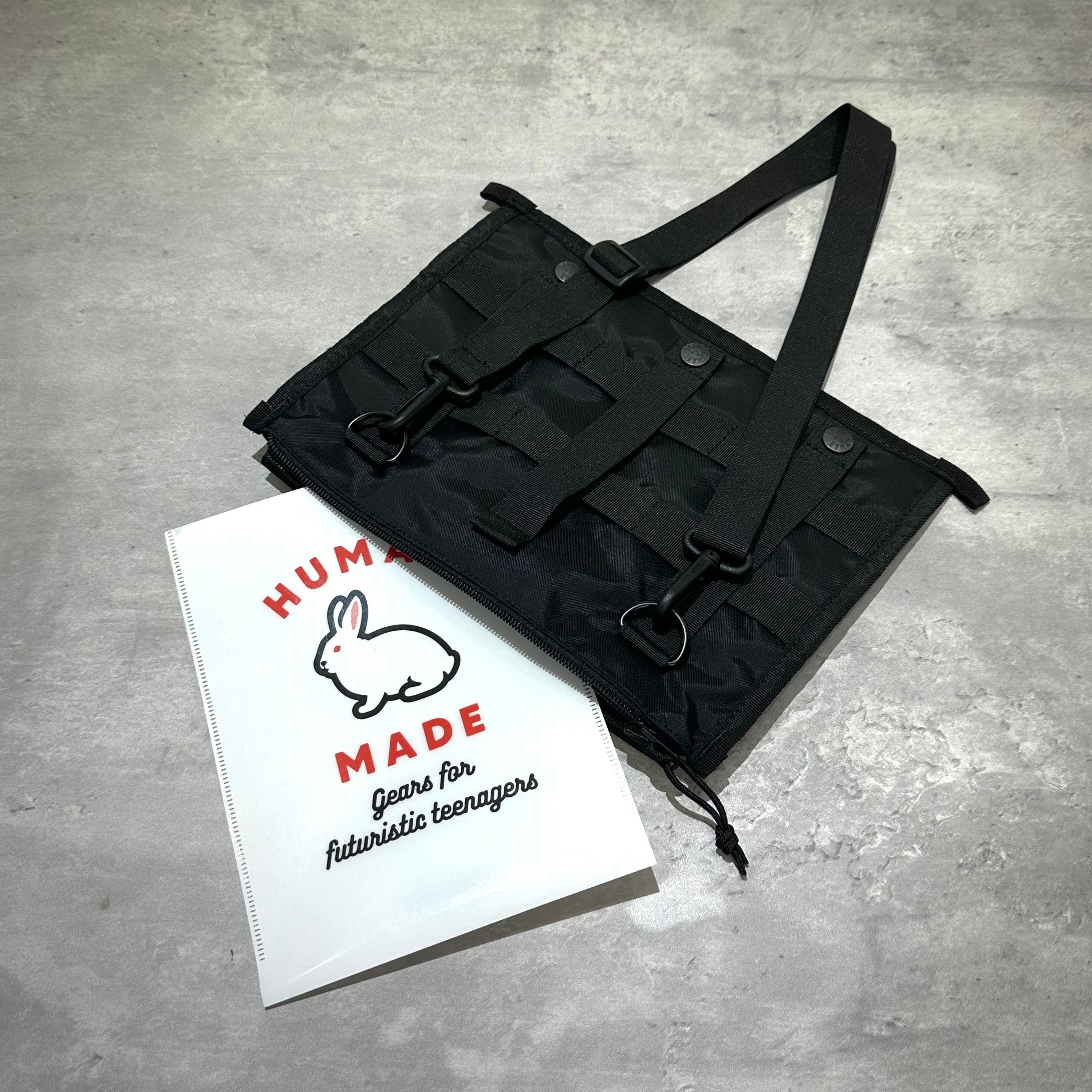 Human Made Military Shoulder Bag HM32GD011 與 Human Made 品牌手冊，從上方角度拍攝的黑色包包