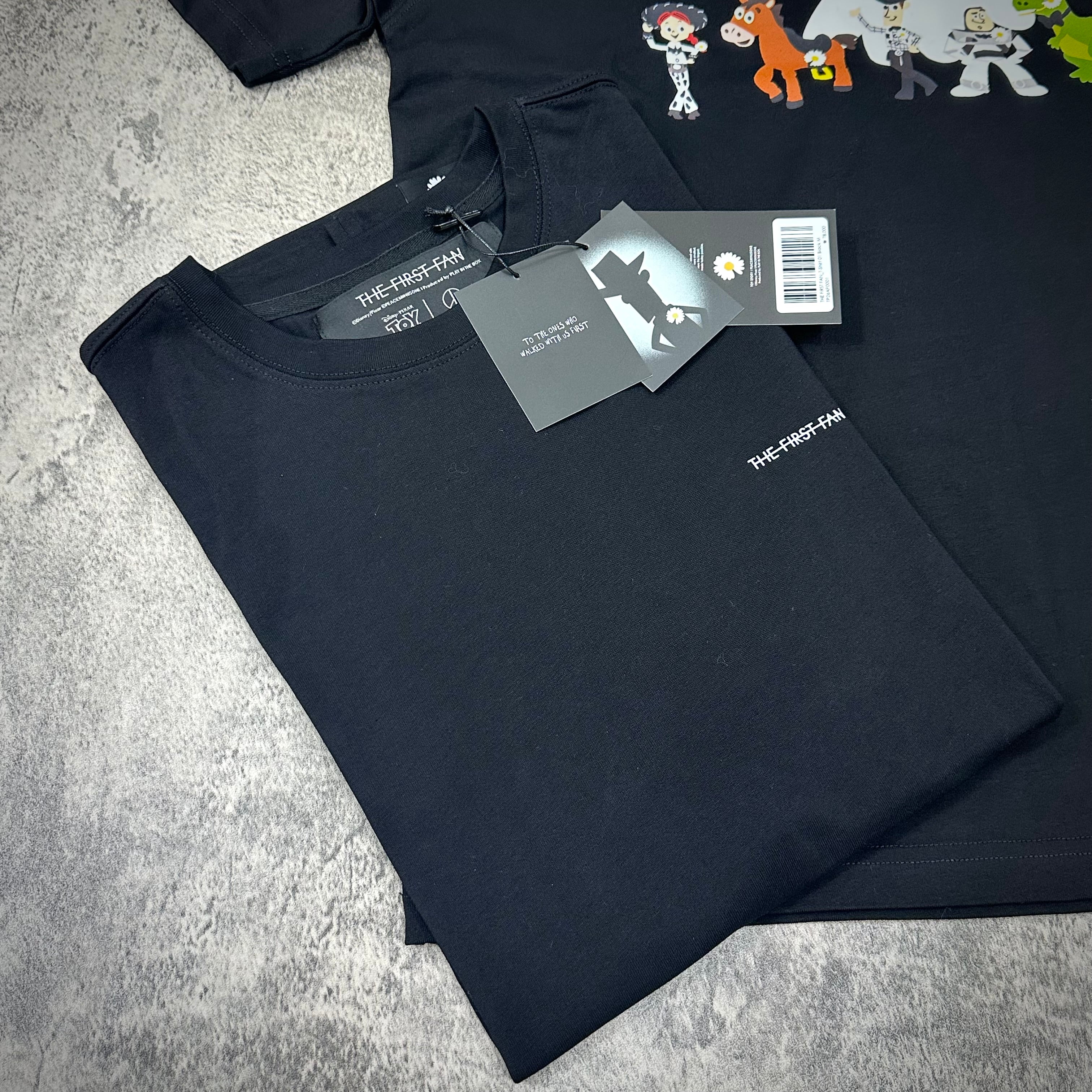 PEACEMINUSONE x Toy Story The First Fan - T-Shirt displayed on a grey background with tags