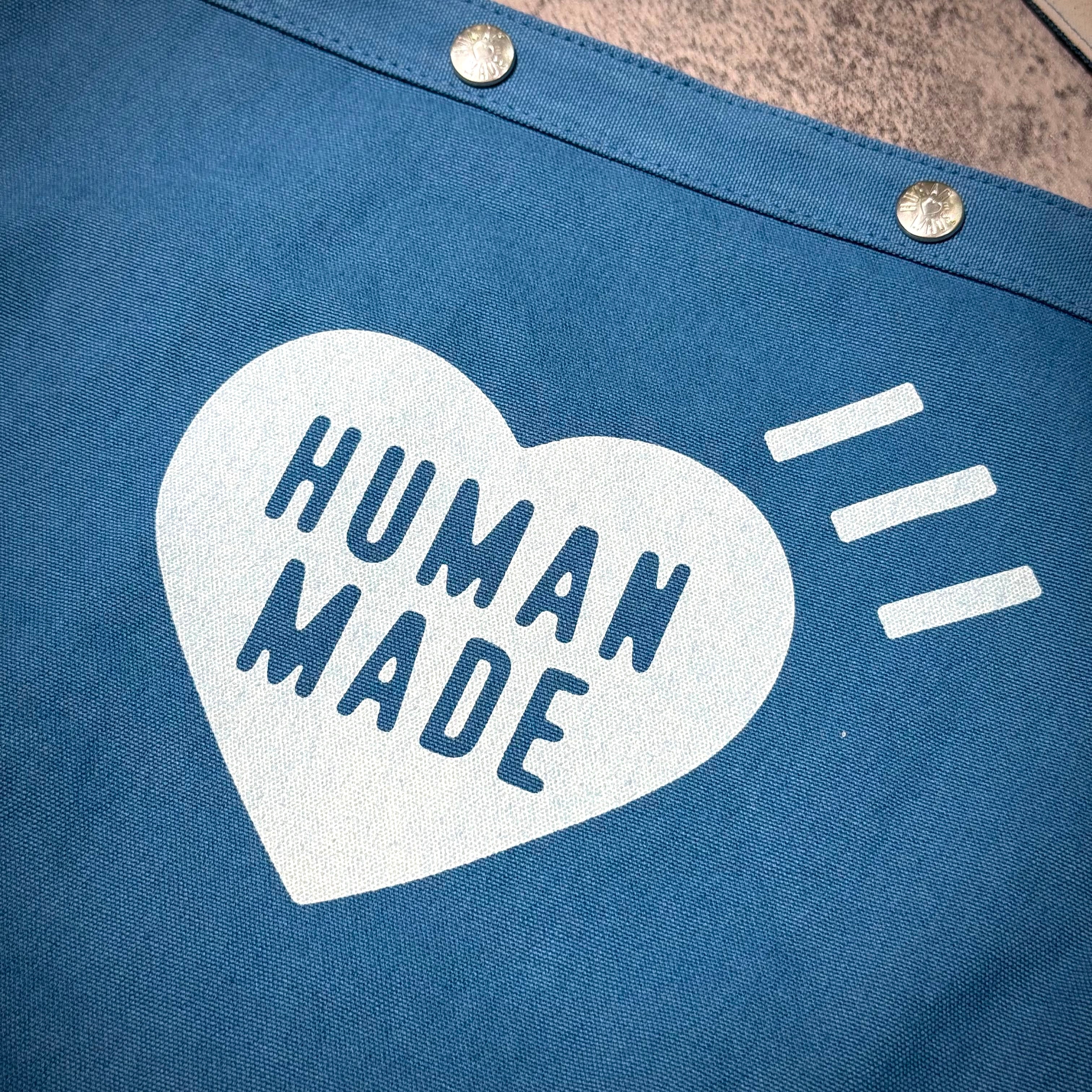 Close-up of Human Made Paper Boy Bag featuring heart design with the text 'HUMAN MADE'.