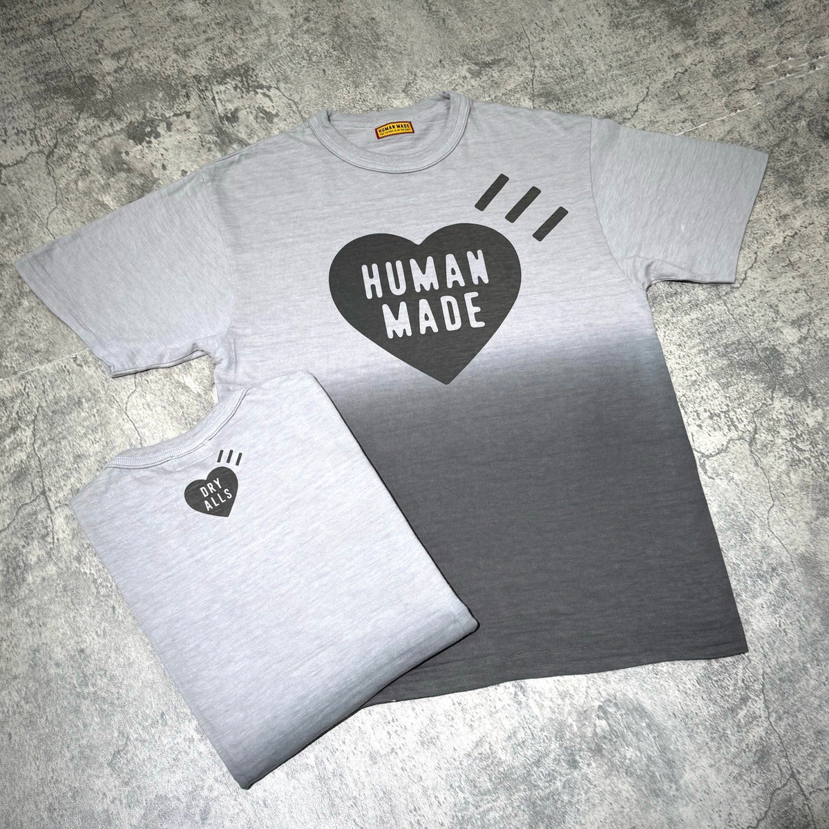 Human Made Tokyo Exclusive Gradation Tee featuring a heart design in gradient grey scale on a textured background.