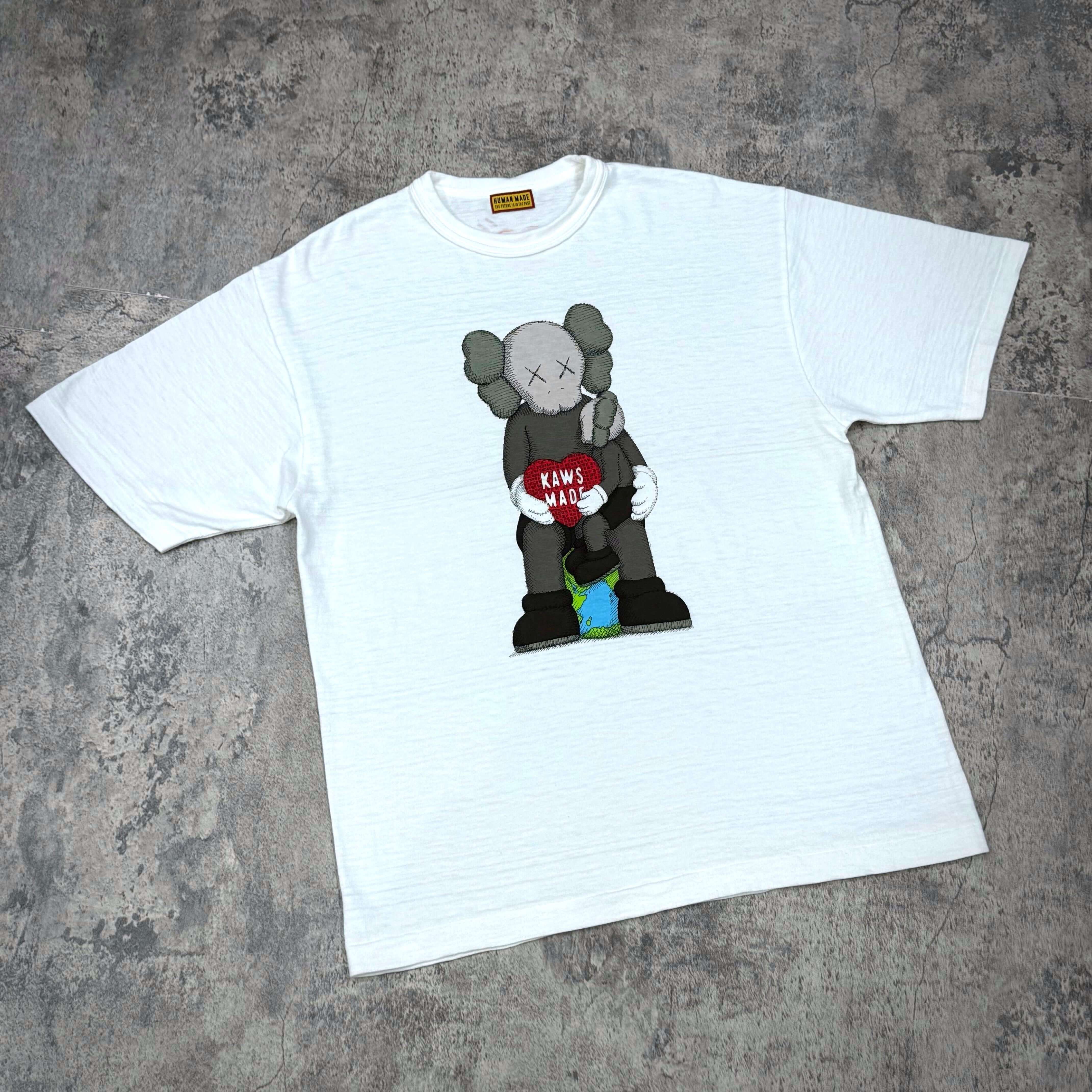 Human Made Bangkok Exclusive Thailand Kaws Holiday Logo Tee featuring Kaws character design on a white shirt.