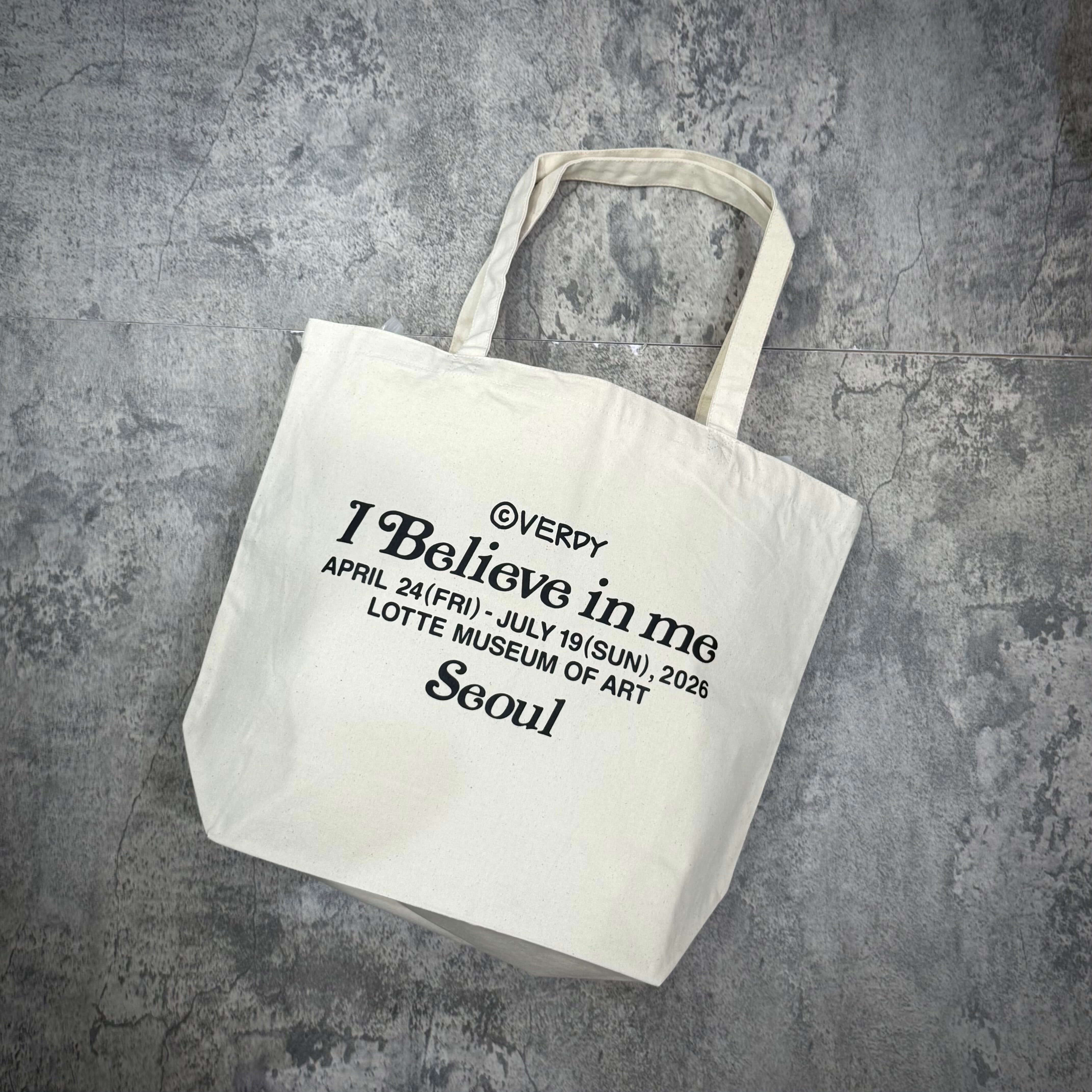 Verdy I Believe in me Tote Bag featuring the text and event details printed on a white canvas fabric.