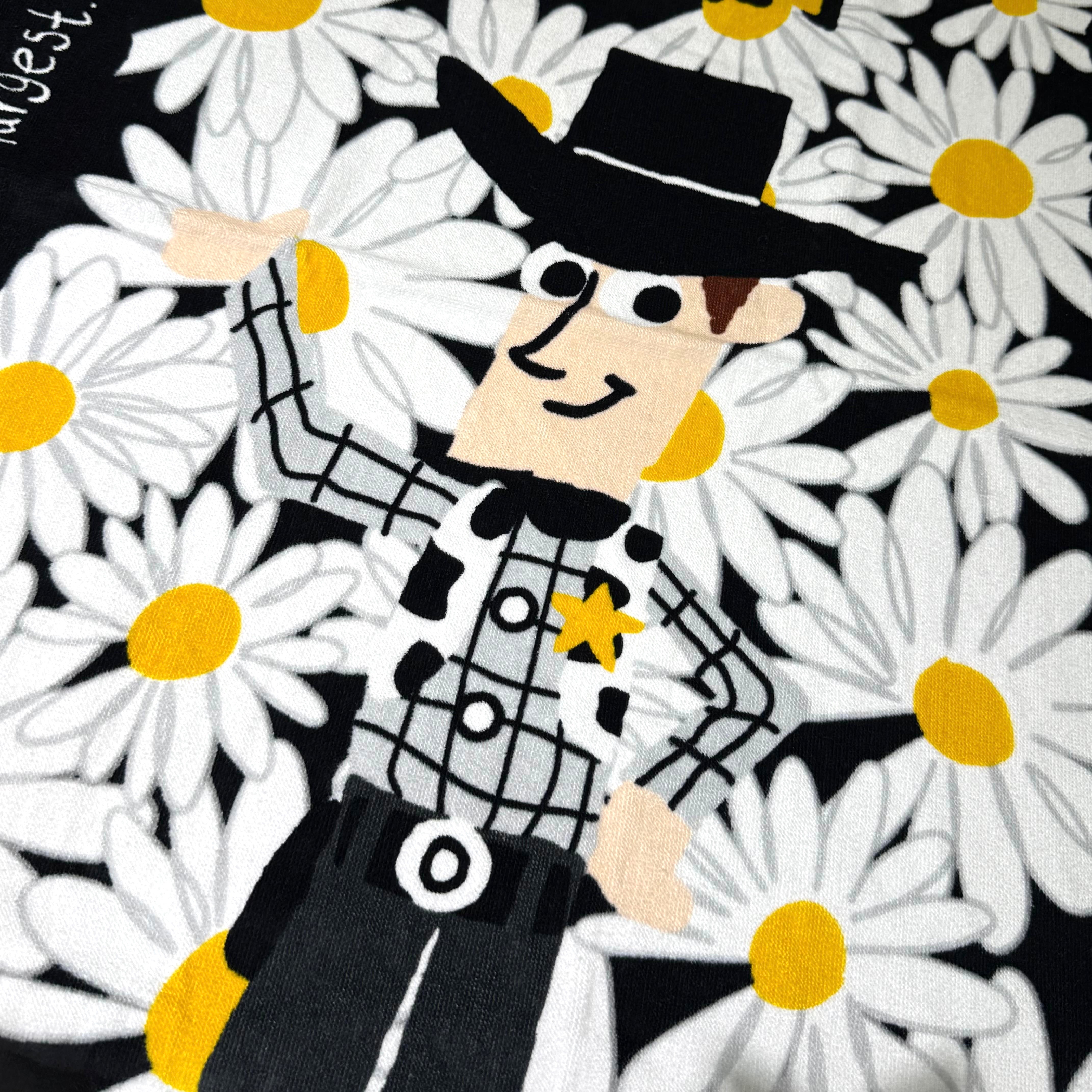 PEACEMINUSONE x Toy Story beach towel featuring a cartoon sheriff character surrounded by daisies.