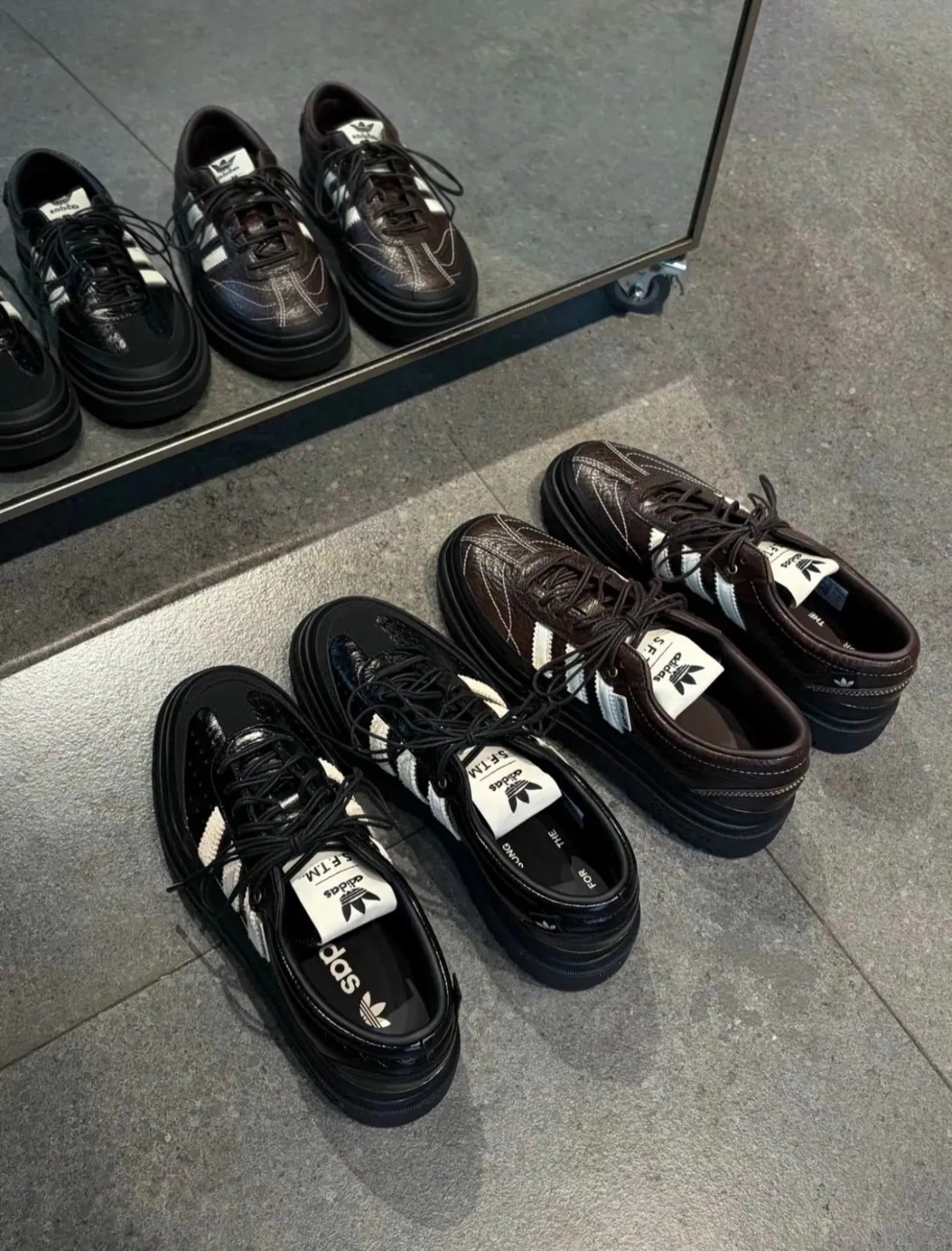 adidas Samba LX Freizeit x Song For The Mute 黑色與棕色運動鞋展示在鏡子前的照片