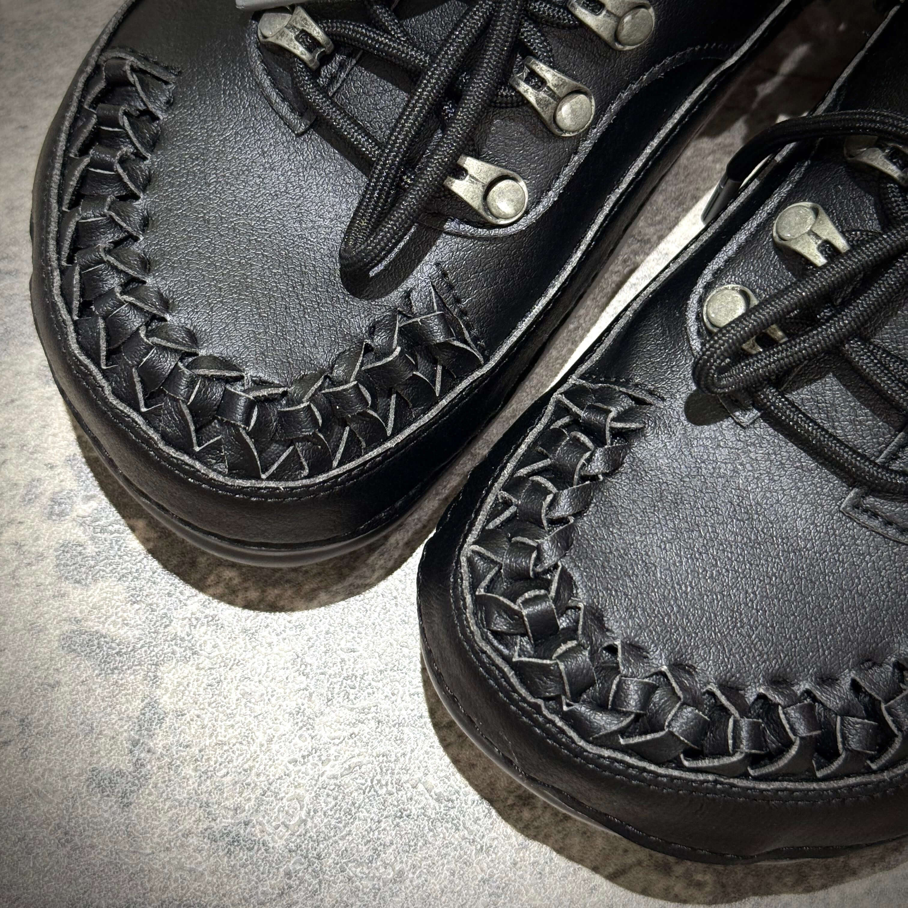 ANDERSSON BELL x Crocs Classic Clog featuring detailed black woven design and metal eyelets.