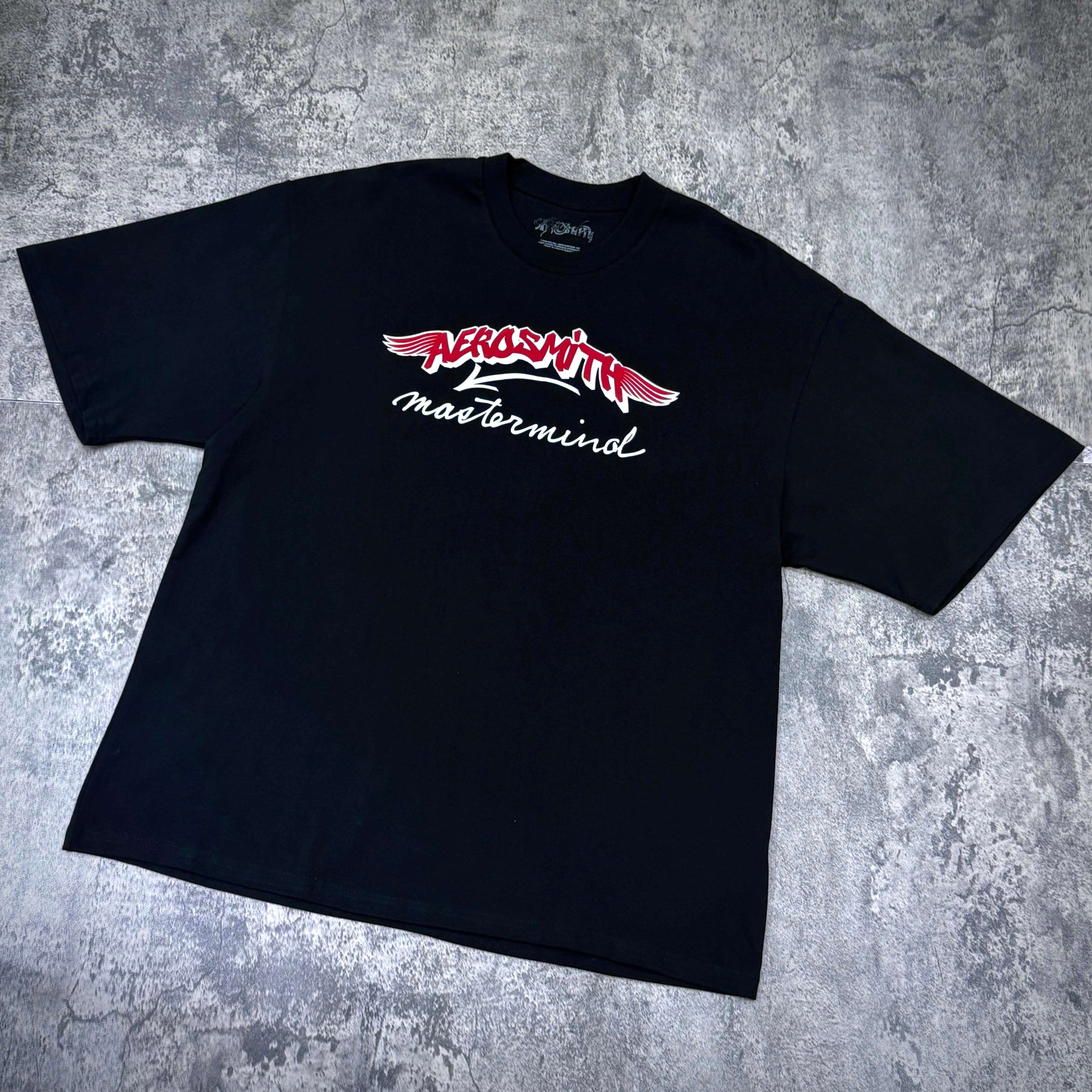 Aerosmith x Mastermind World Let Rock Rule S/S Tee featuring bold logo design on a black t-shirt.