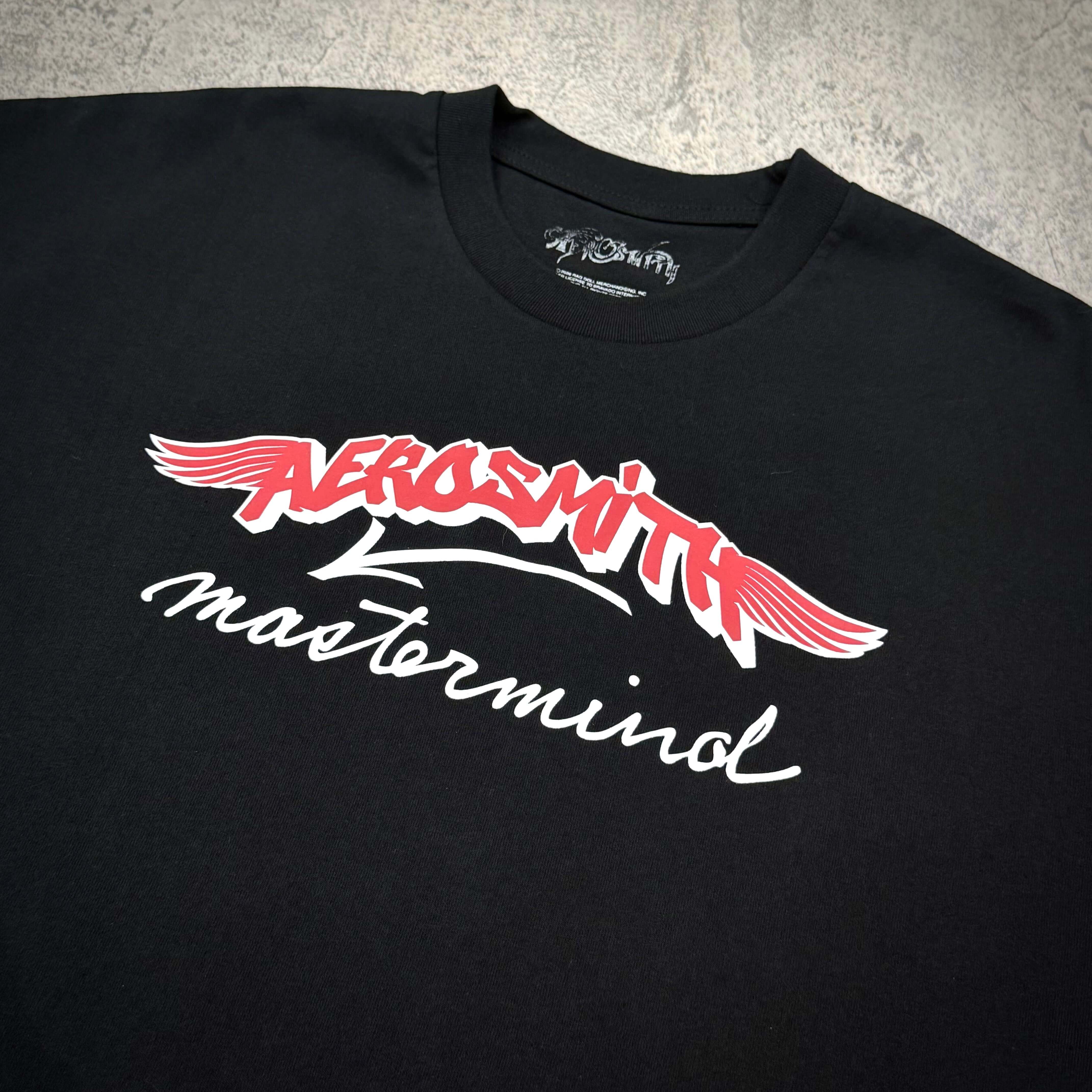Aerosmith x Mastermind World Let Rock Rule S/S Tee featuring iconic Aerosmith logo on black fabric.