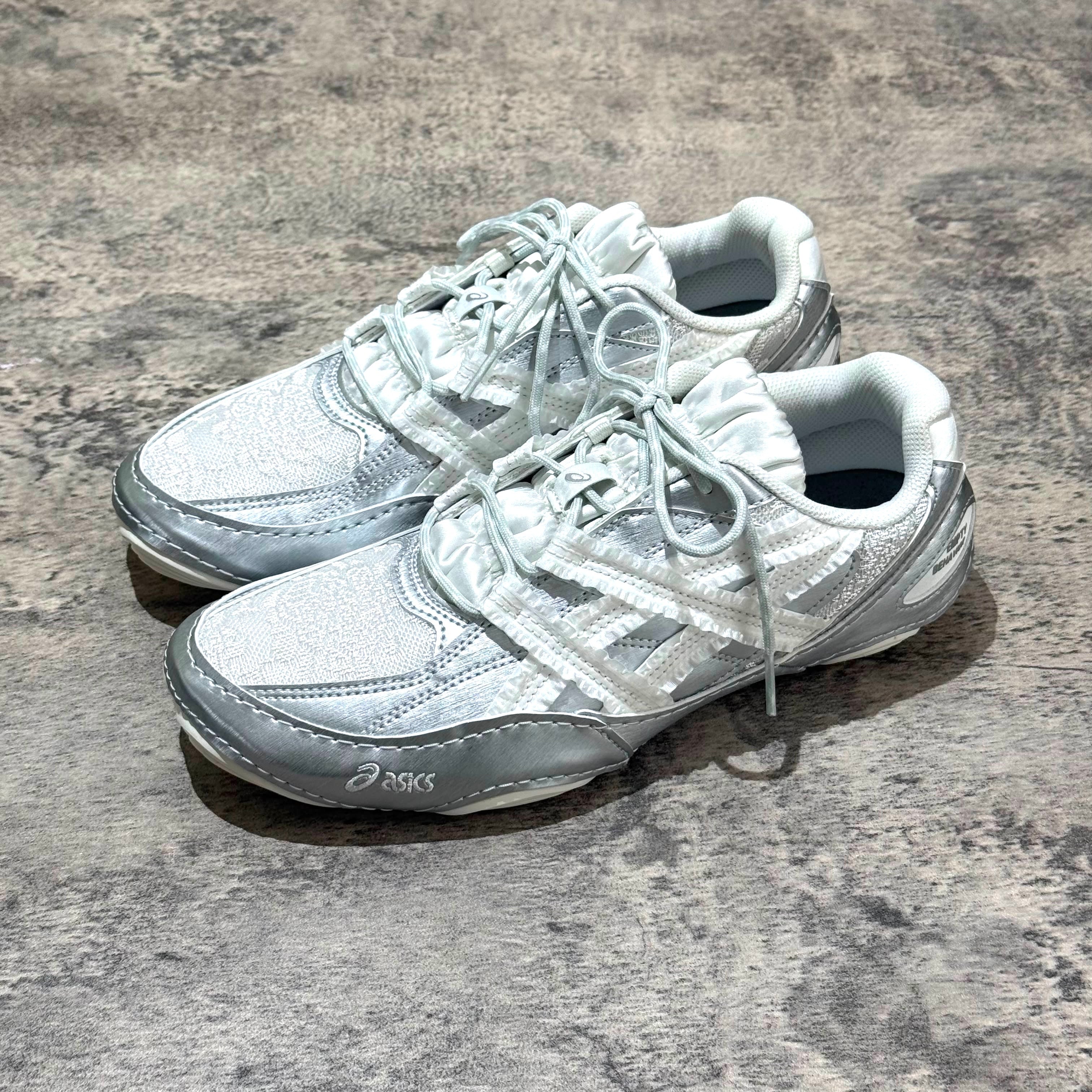 Asics x Empty Behavior Hypersync in Pure Silver White lying on a textured surface.