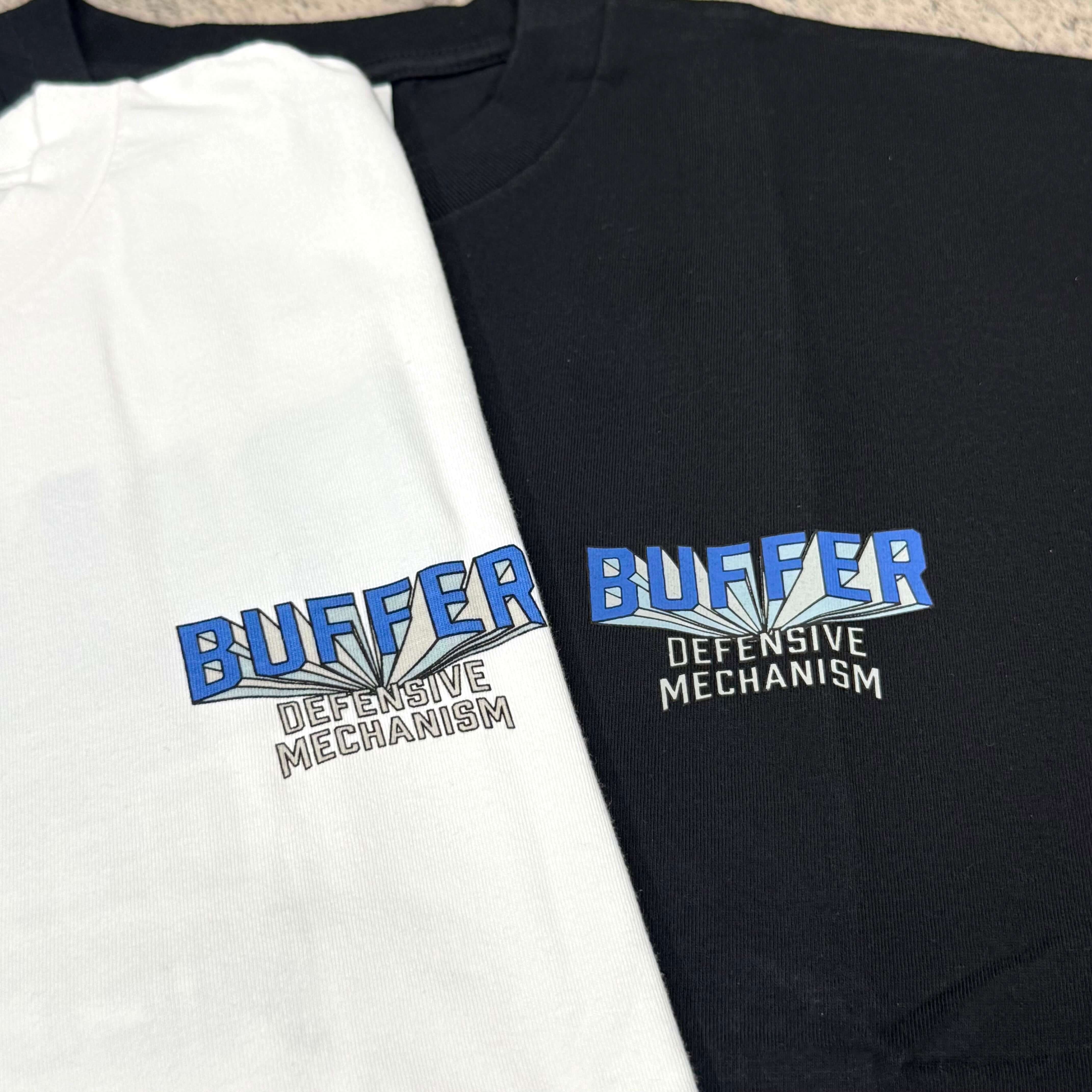 Buffer Gravity Tee - Black and White design featuring 'BUFFER DEFENSIVE MECHANISM' graphic on fabric.