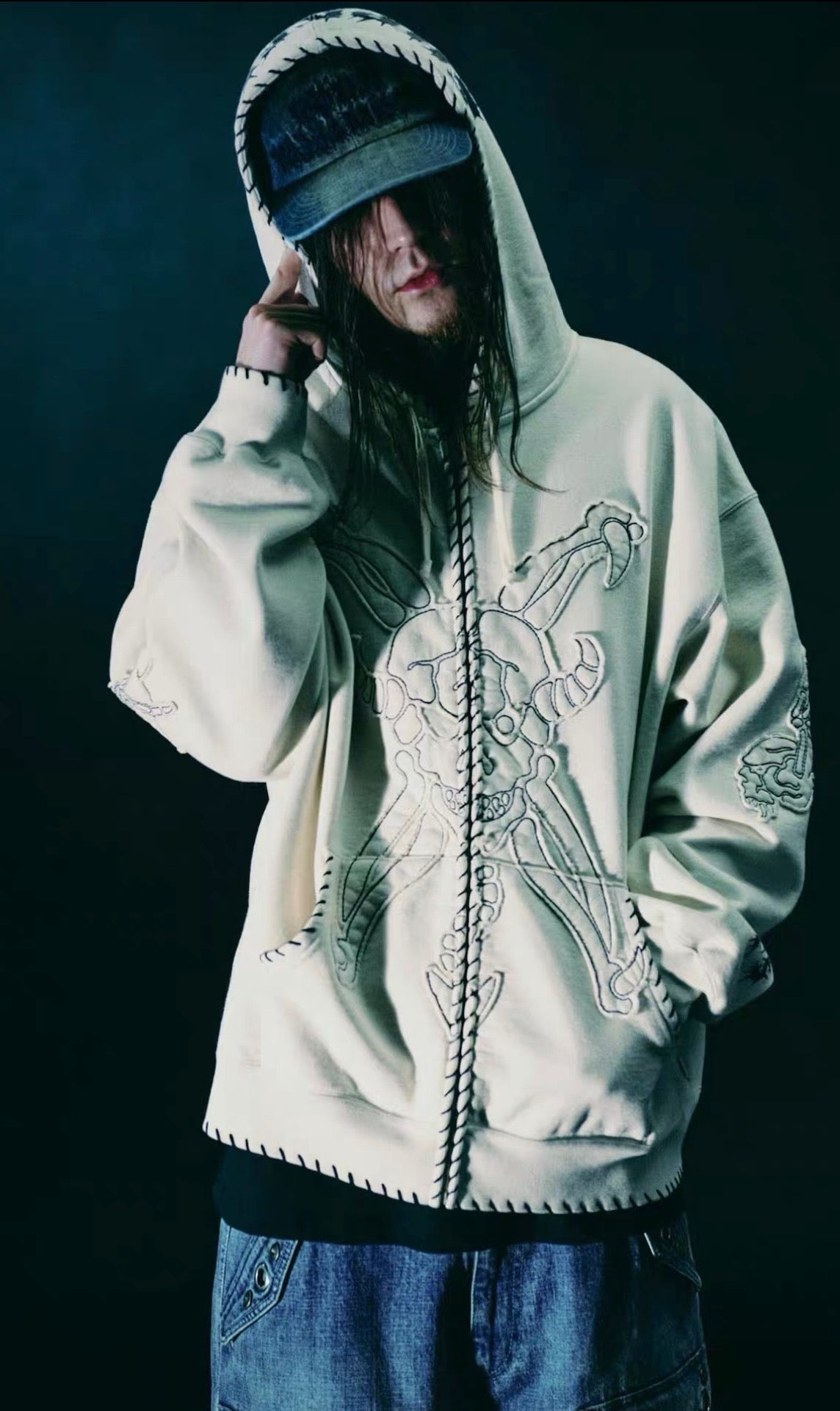 Supreme x Y's by Yohji Yamamoto Zip Up Hooded Sweatshirt - Natural worn by a model with long hair in a dark setting.