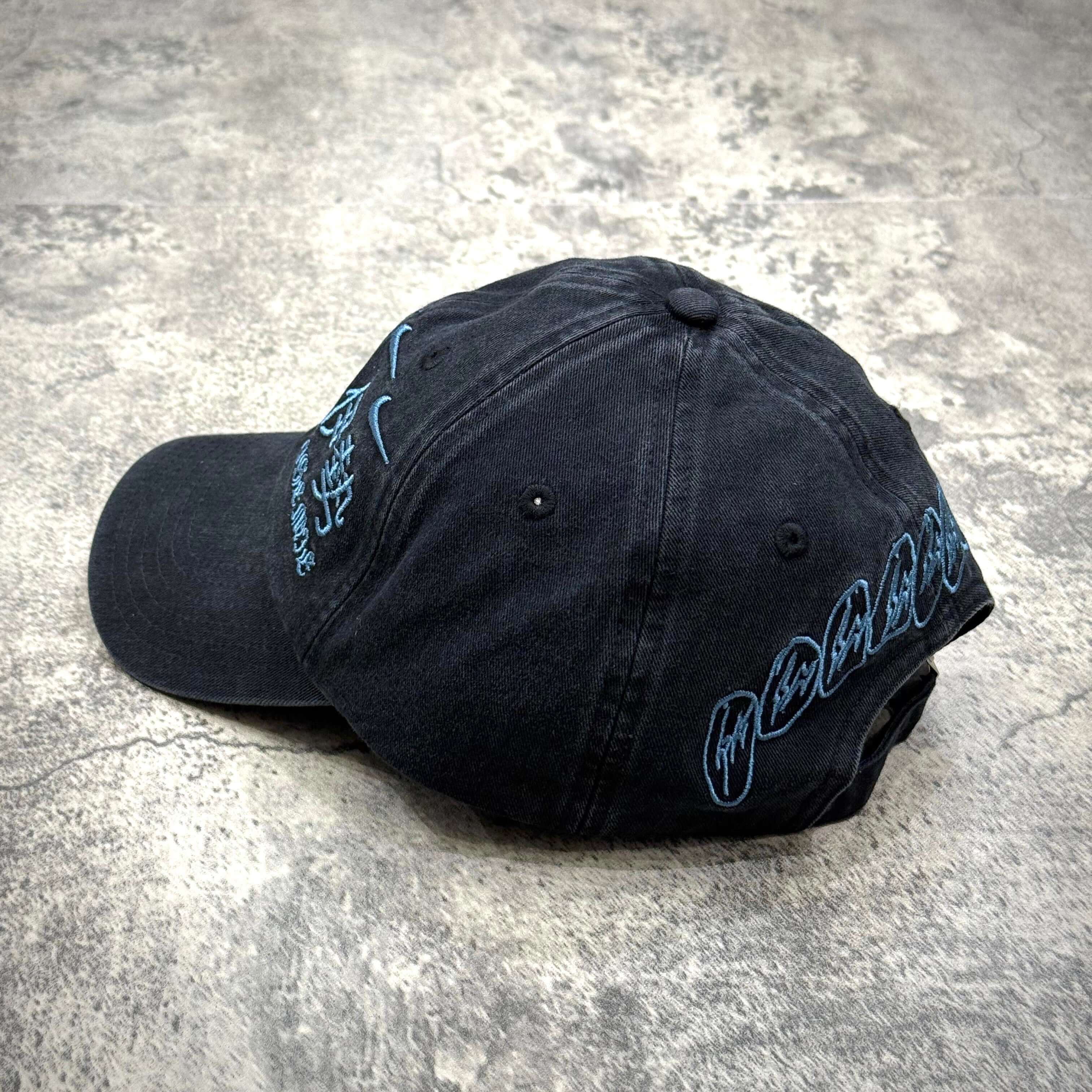 Cactus Jack x Fragment x Nike Houston to Ise Mie Hat side view showcasing black fabric and blue detailing.