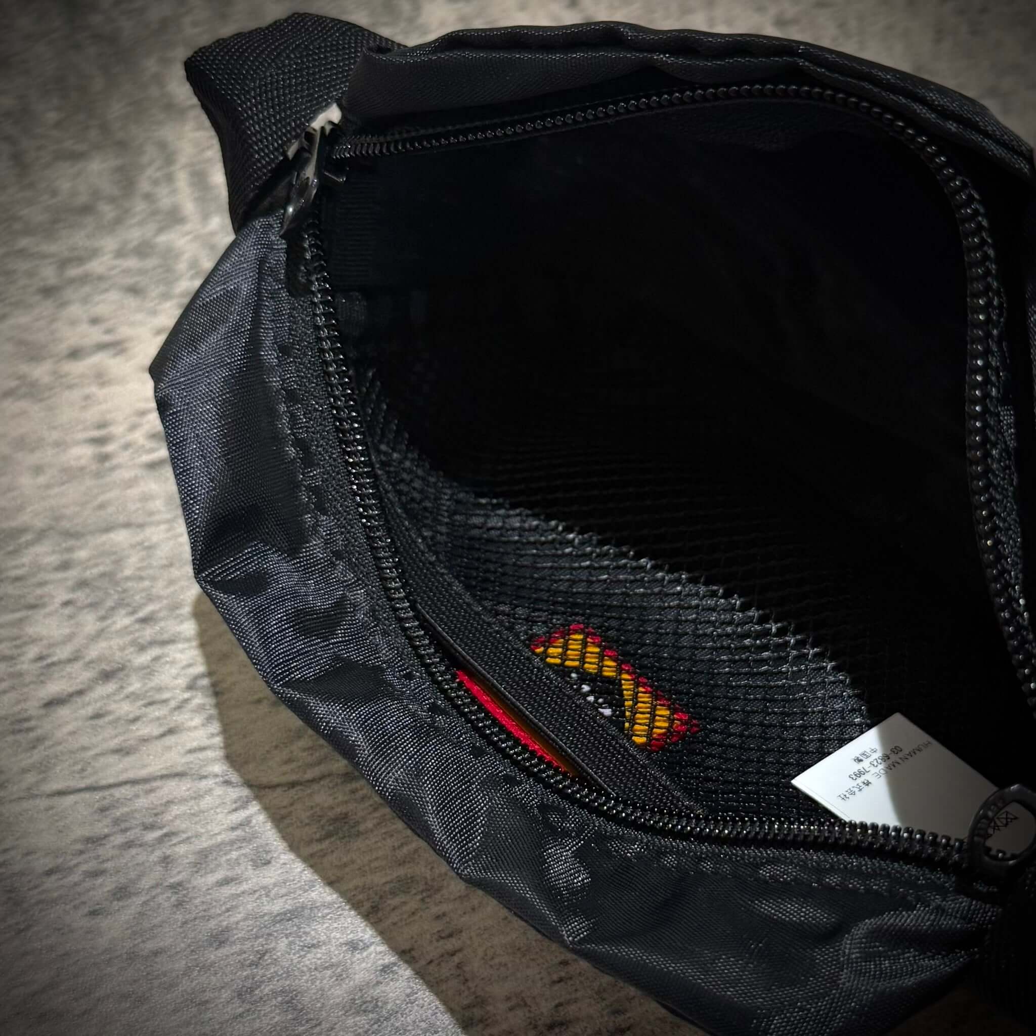 Interior view of the Human Made Travel Pouch showcasing its zipper and mesh pocket.