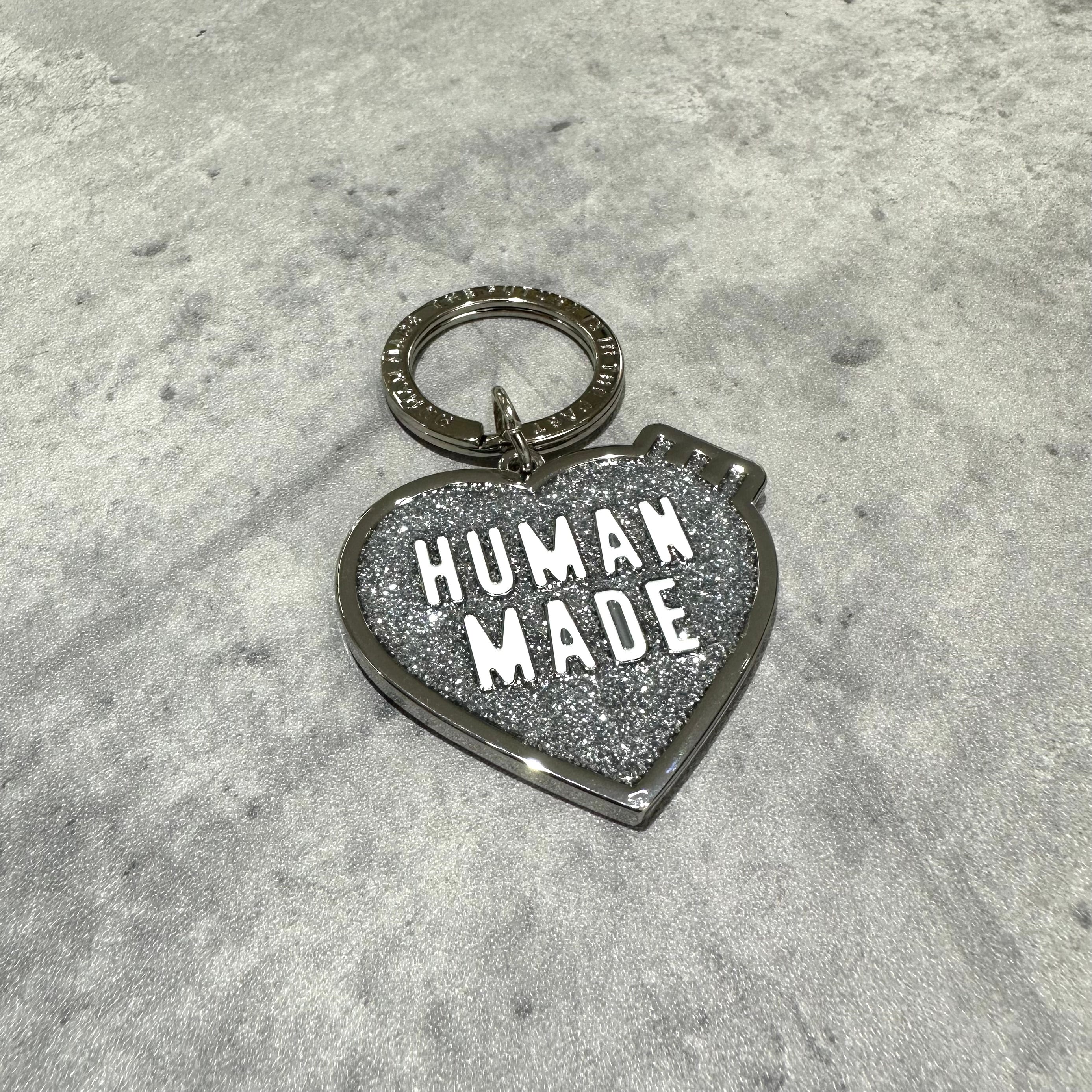 Human Made Store Exclusive Heart Keychain with glitter finish and metal keyring on a gray surface.