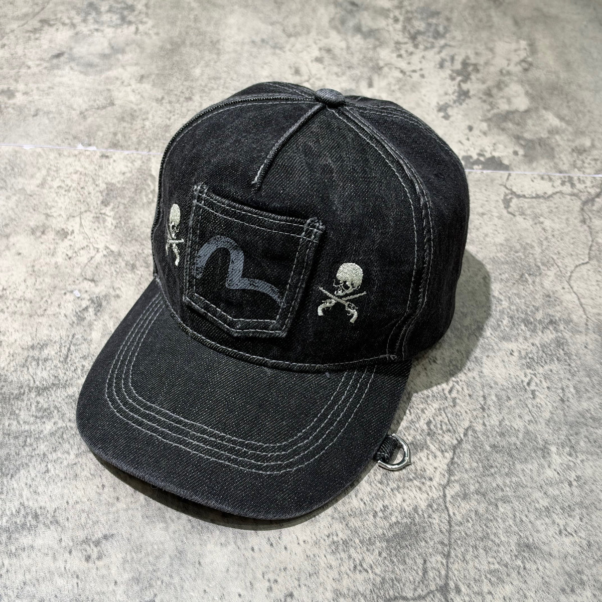 Evisu x Mastermind Japan x Roarguns Cap featuring a denim design with skull graphics on a black cap.