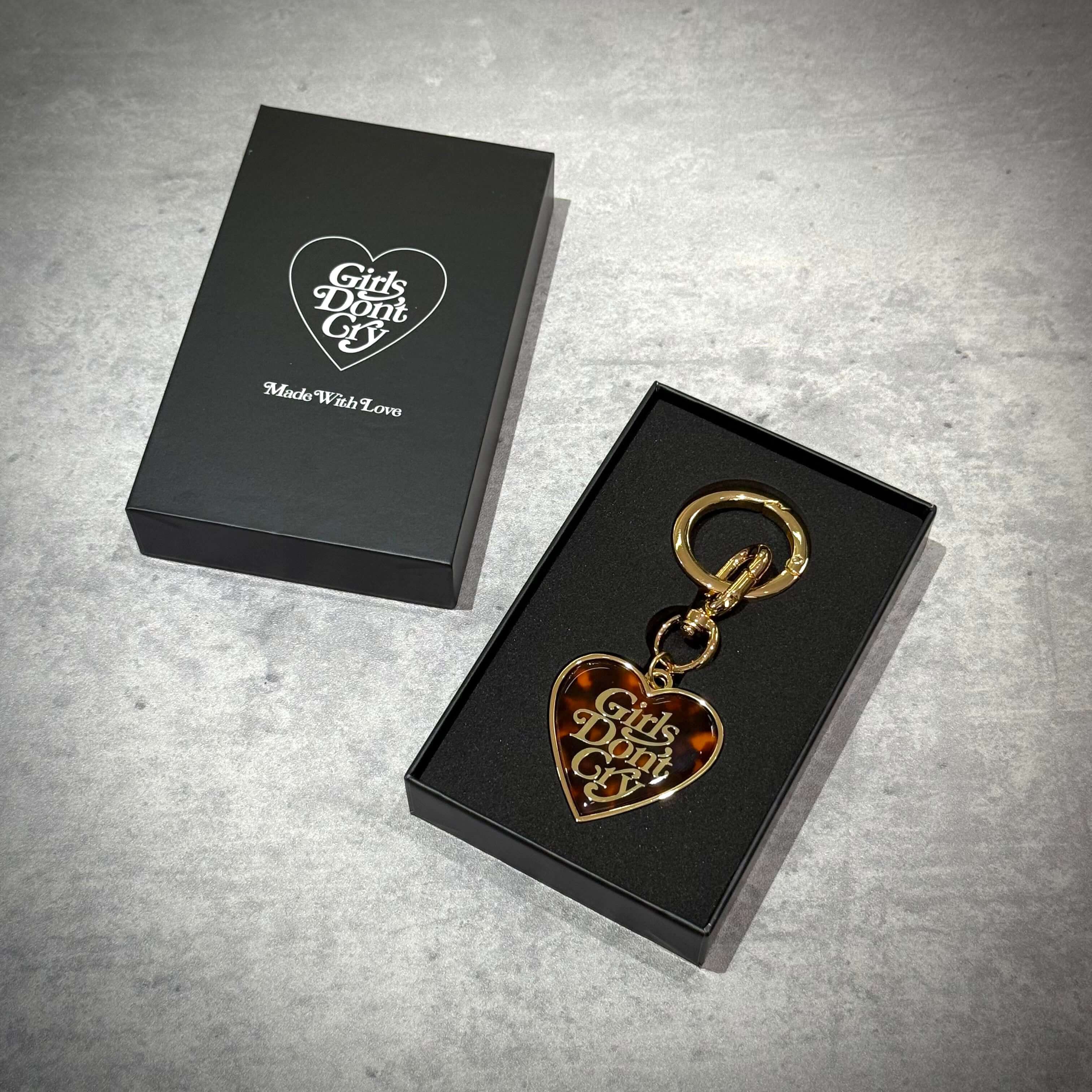 Girls Don't Cry Tortoise Shell Keyring displayed in a black box with gold accents.