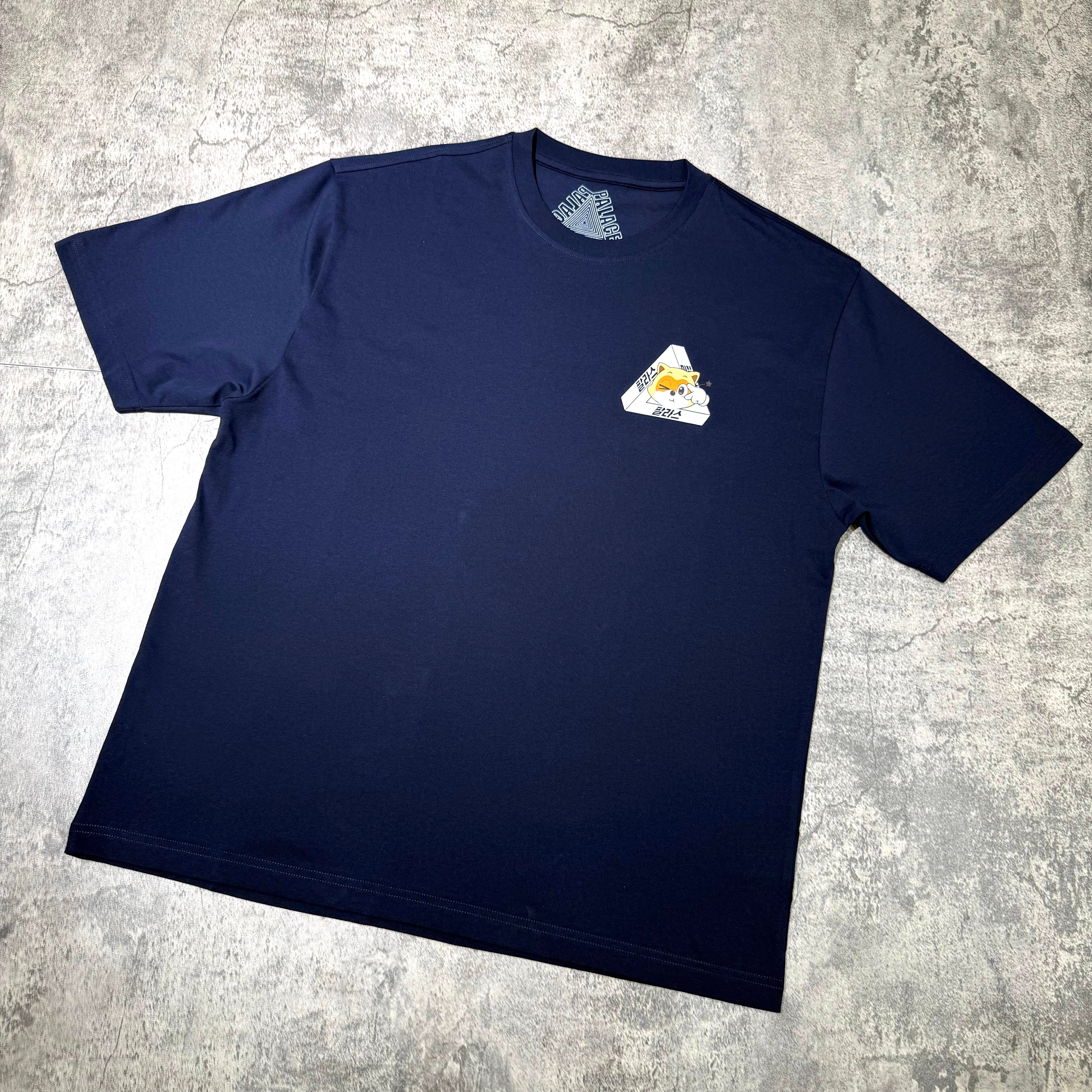 Palace Jamsil Exclusive Lotte Tri-ferg Tee displayed on a gray surface wearing a navy color.