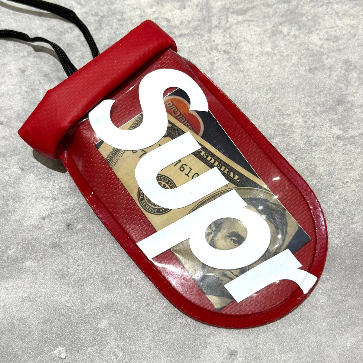 Supreme SealLine See Pouch Small Red with cash inside and a clear front for visibility.